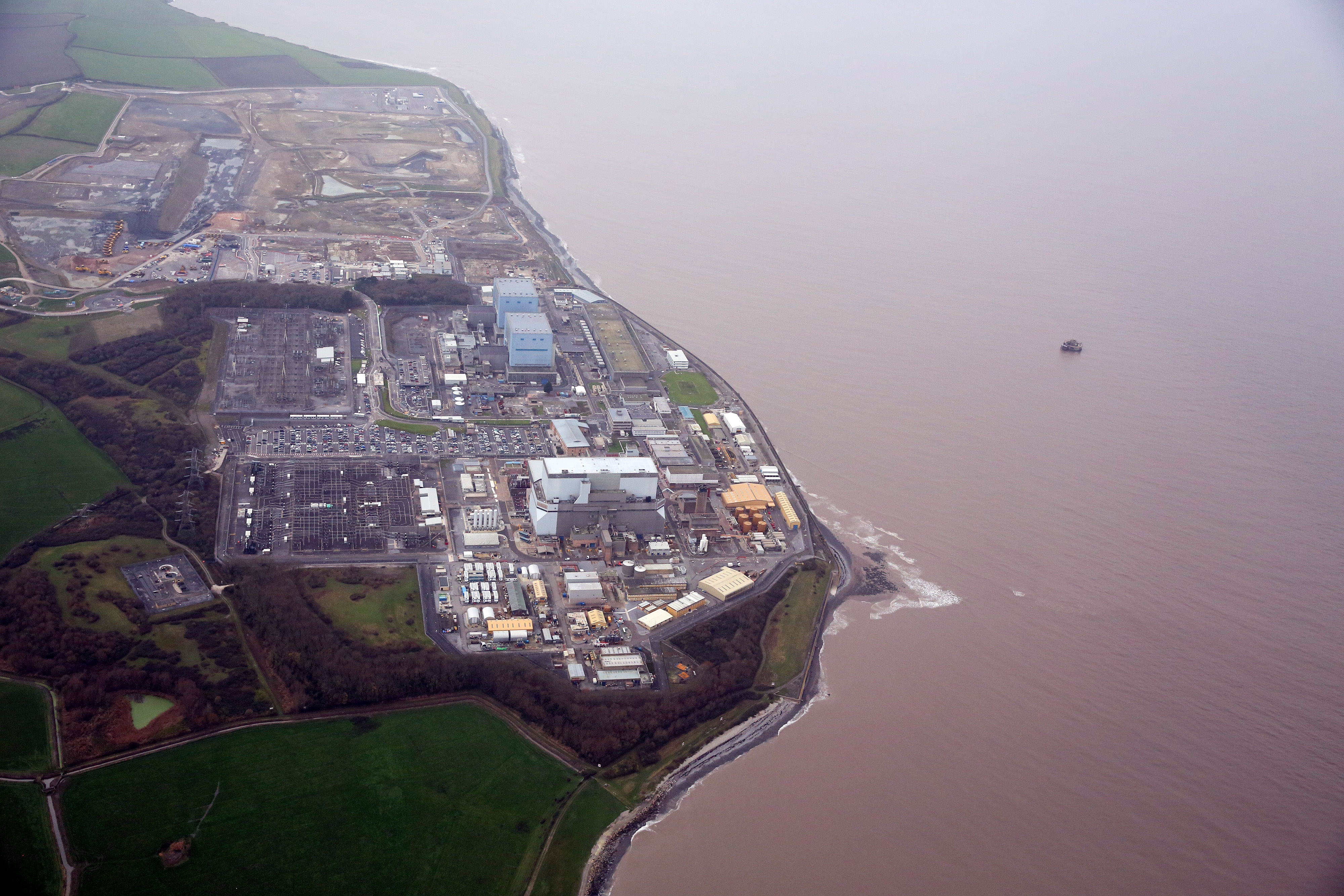Hinkley Point B nuclear power station, operated by Electricite de France SA's (EDF), right, stands near to groundworks for Hinkley Point C near Bridgwater, U.K., on Thursday, Dec. 17, 2015.