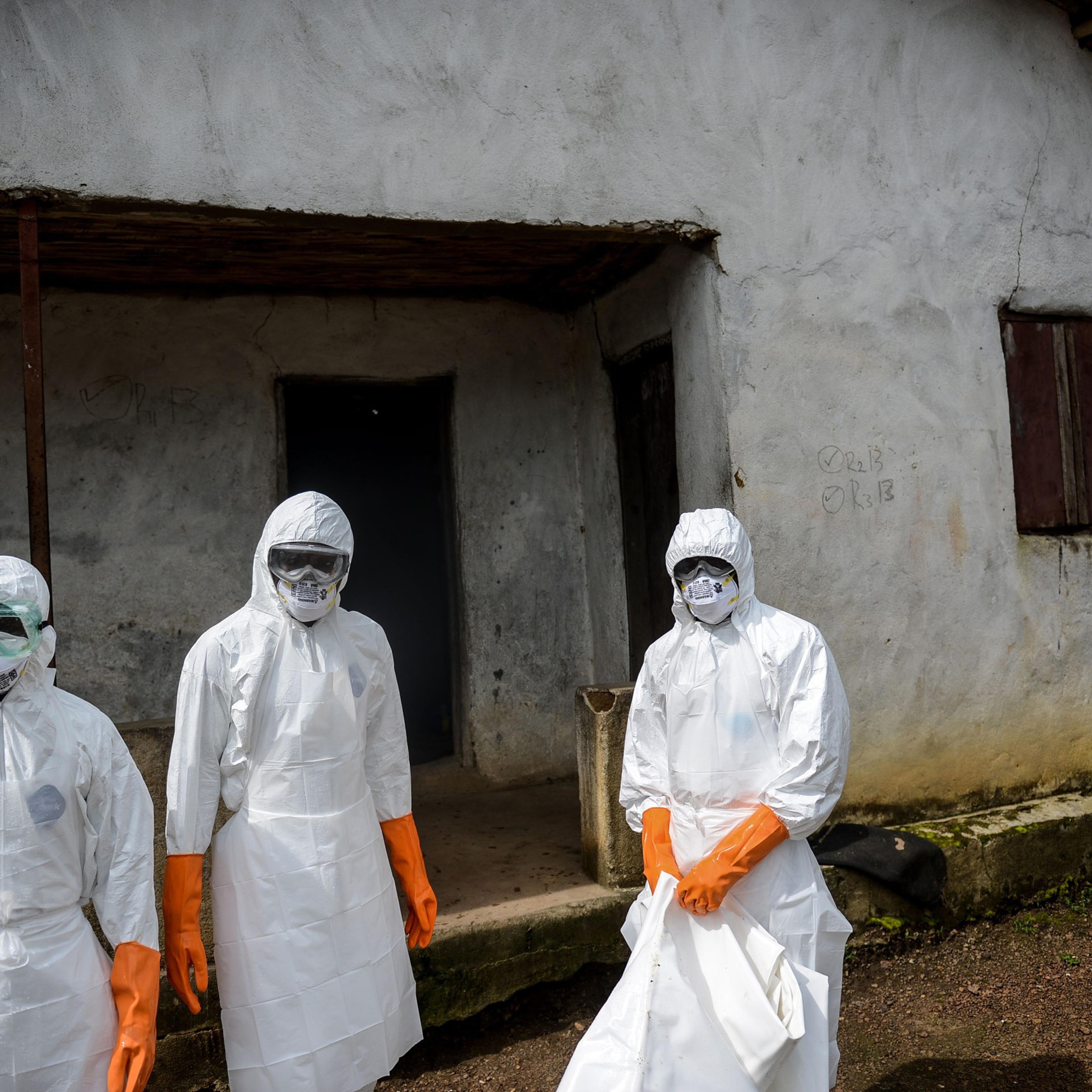 A group of young volunteers wear special uniforms sterilize round the house after Baindu Koruma (28) died due to the Ebola virus, in Lango village, Kenema, Sierra Leone on August 25, 2014.
