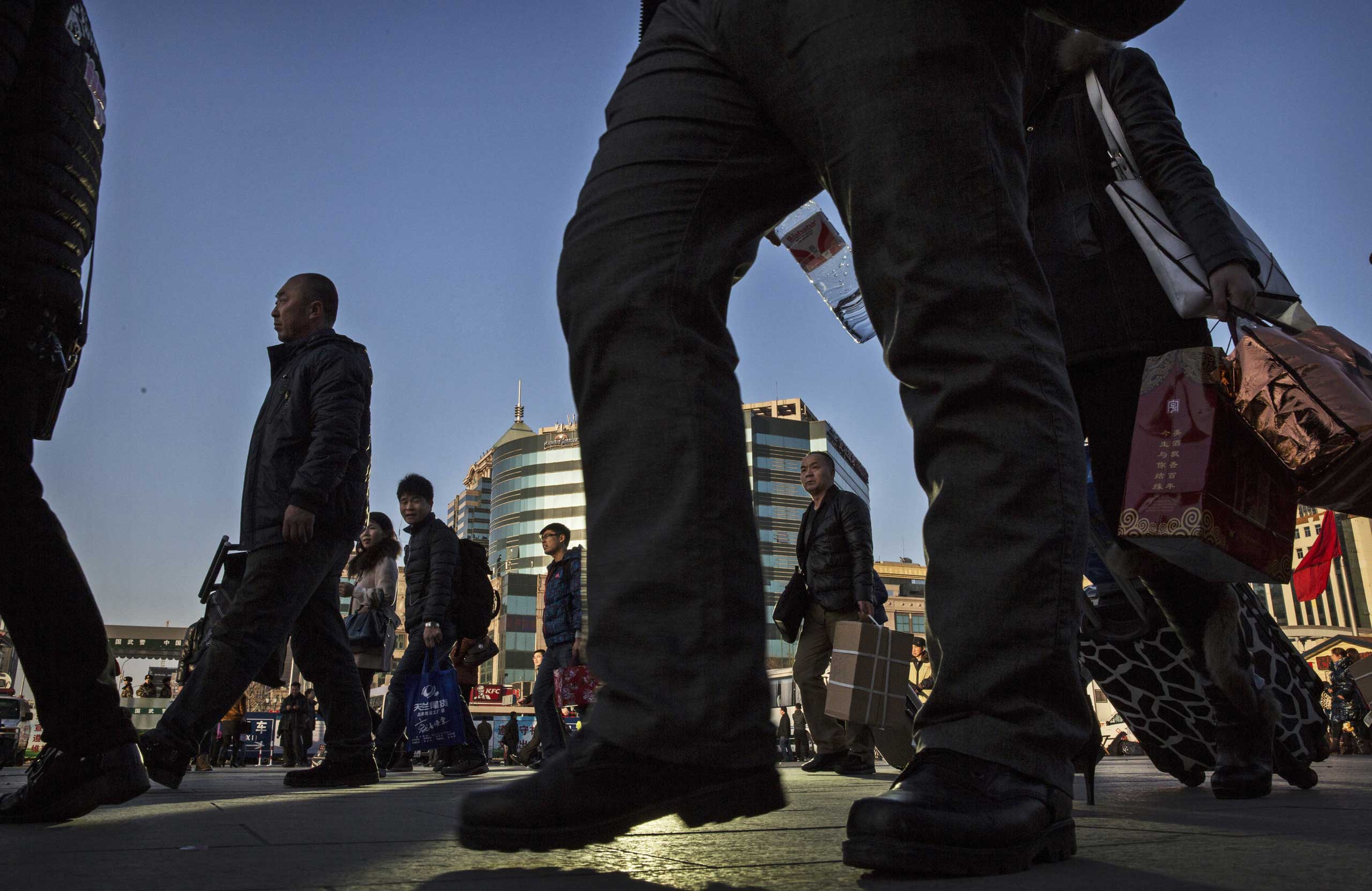 Chinese passengers walk as they make their way to trains as they leave for the Spring Festival at a local railway station on Feb. 17, 2015 in Beijing.