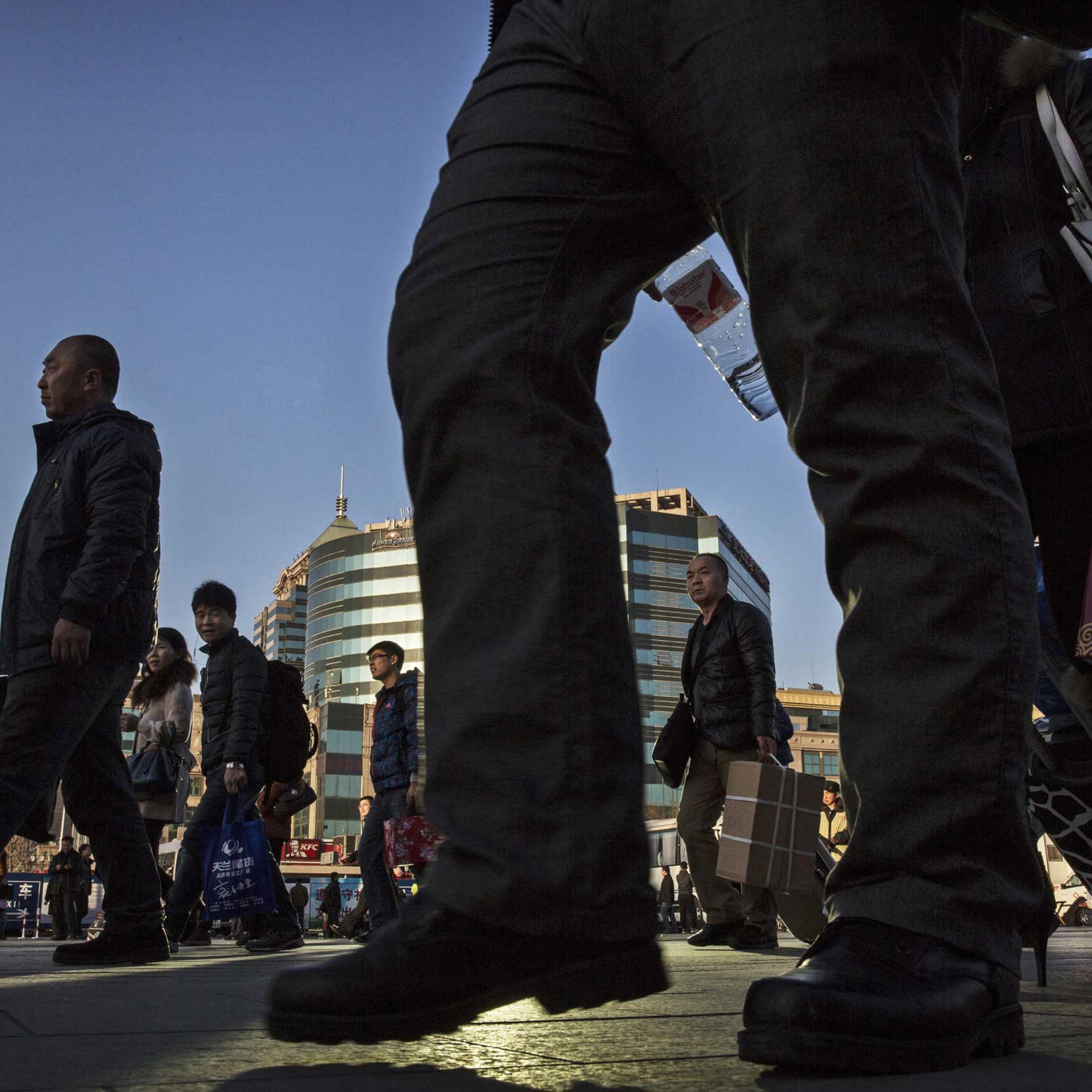Chinese passengers walk as they make their way to trains as they leave for the Spring Festival at a local railway station on Feb. 17, 2015 in Beijing.