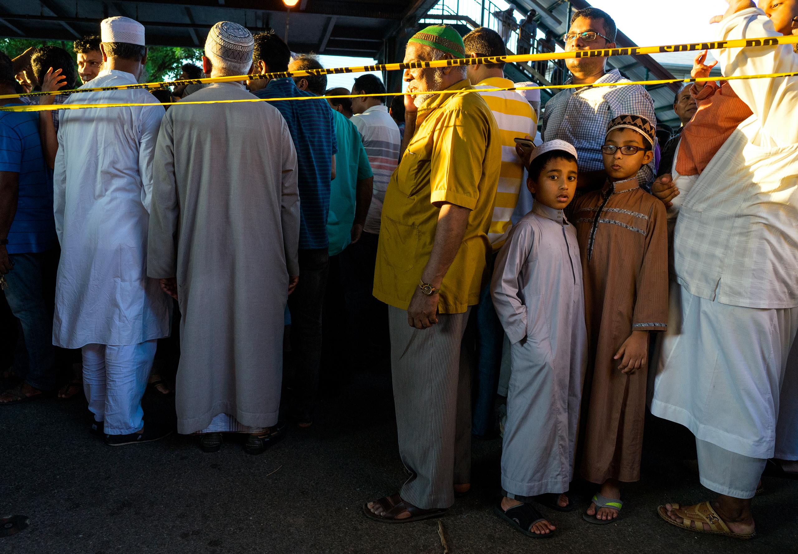 People gather for a demonstration Saturday, Aug. 13, 2016, in the Queens borough of New York, near a crime scene after the leader of a New York City mosque and an associate were fatally shot as they left afternoon prayers. Police said 55-year-old Imam Ma