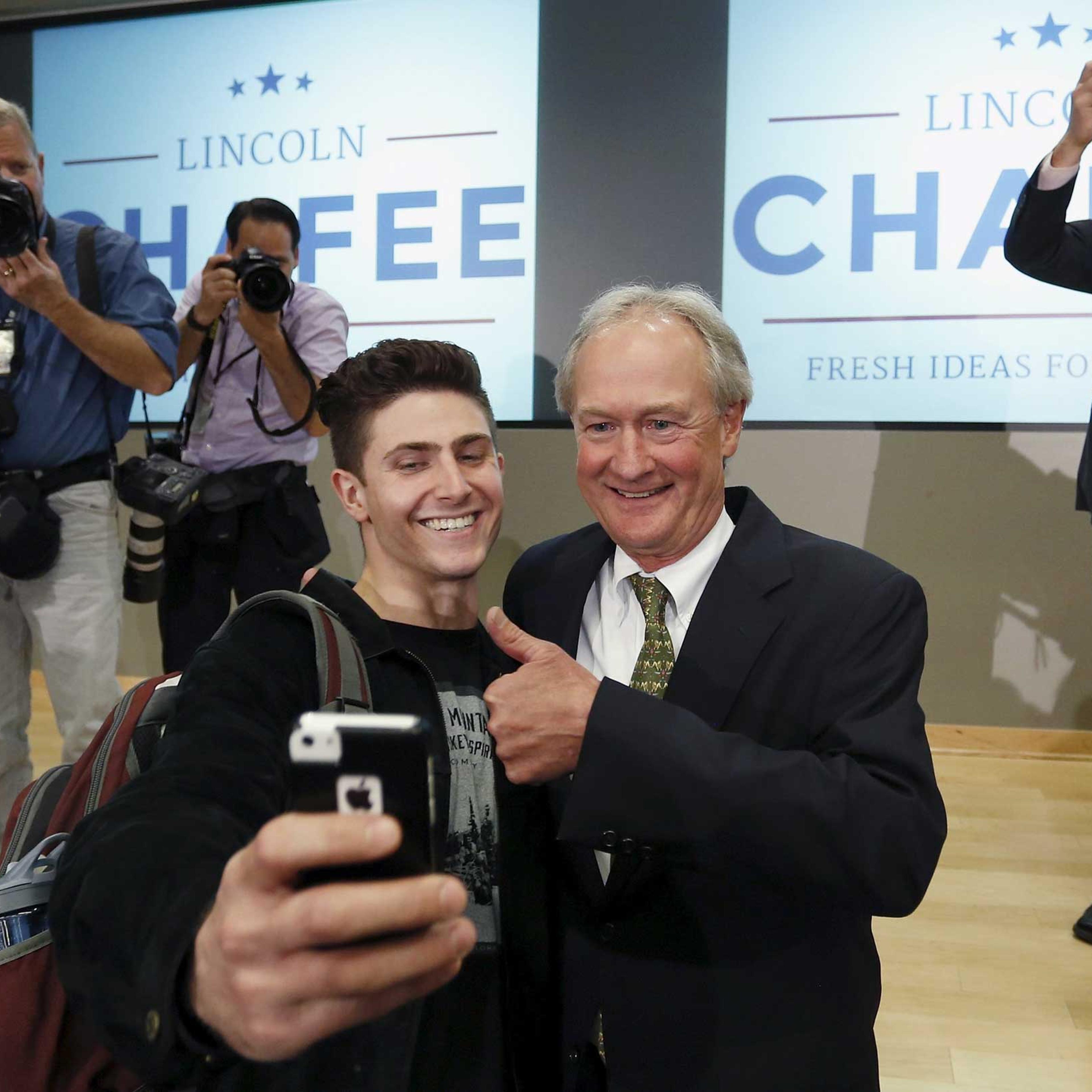 Former Rhode Island Governor Chafee poses for a selfie with a student after announcing he will seek the Democratic nomination to be U.S. president during an address to the GMU School of Policy, Government, and International Affairs in Arlington