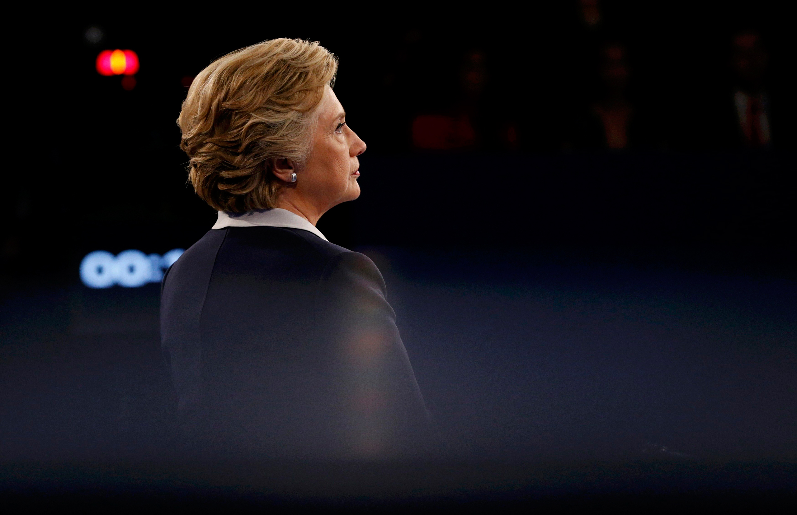 Democratic U.S. presidential nominee Clinton listens as Republican U.S. presidential nominee Trump speaks during their presidential town hall debate in St. Louis