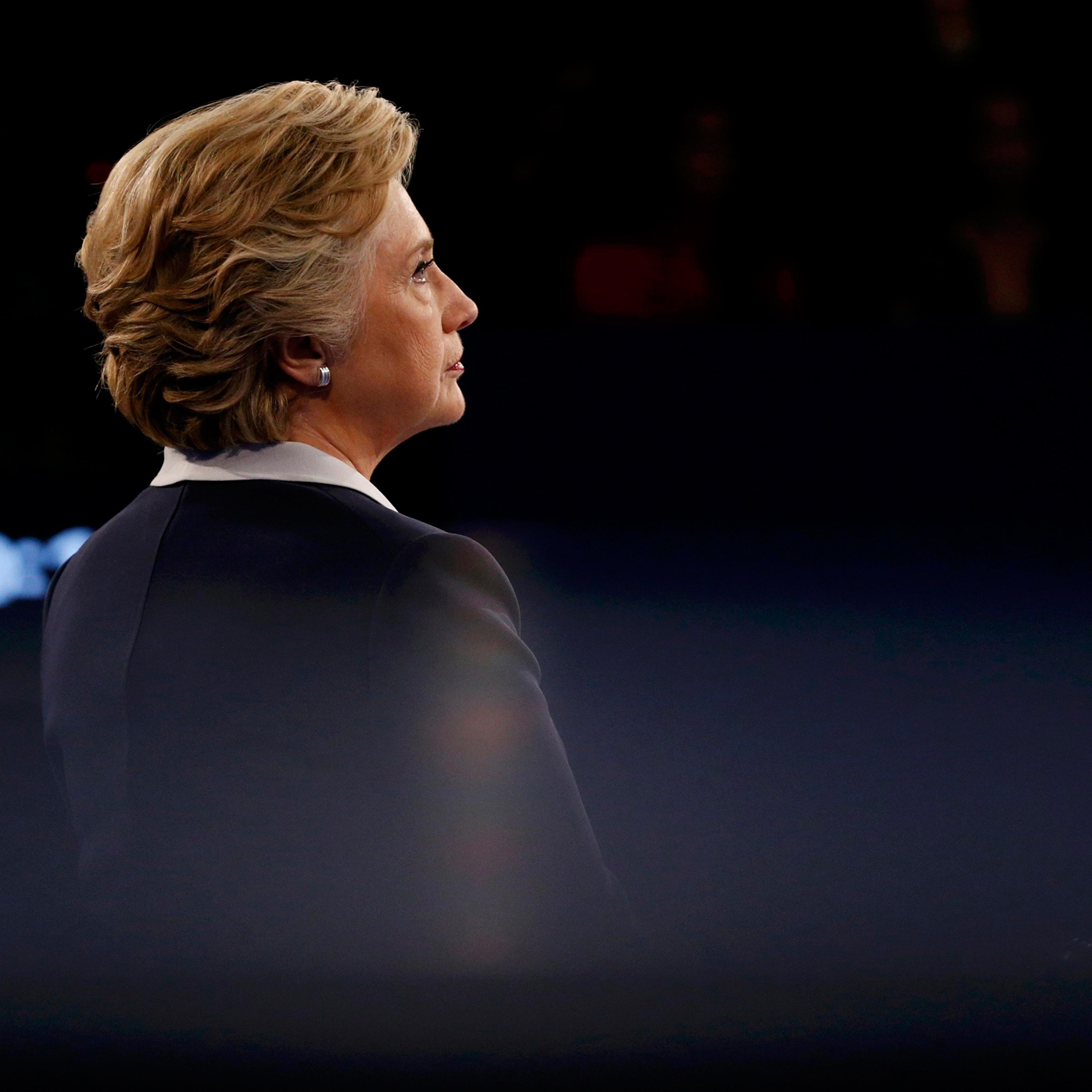 Democratic U.S. presidential nominee Clinton listens as Republican U.S. presidential nominee Trump speaks during their presidential town hall debate in St. Louis