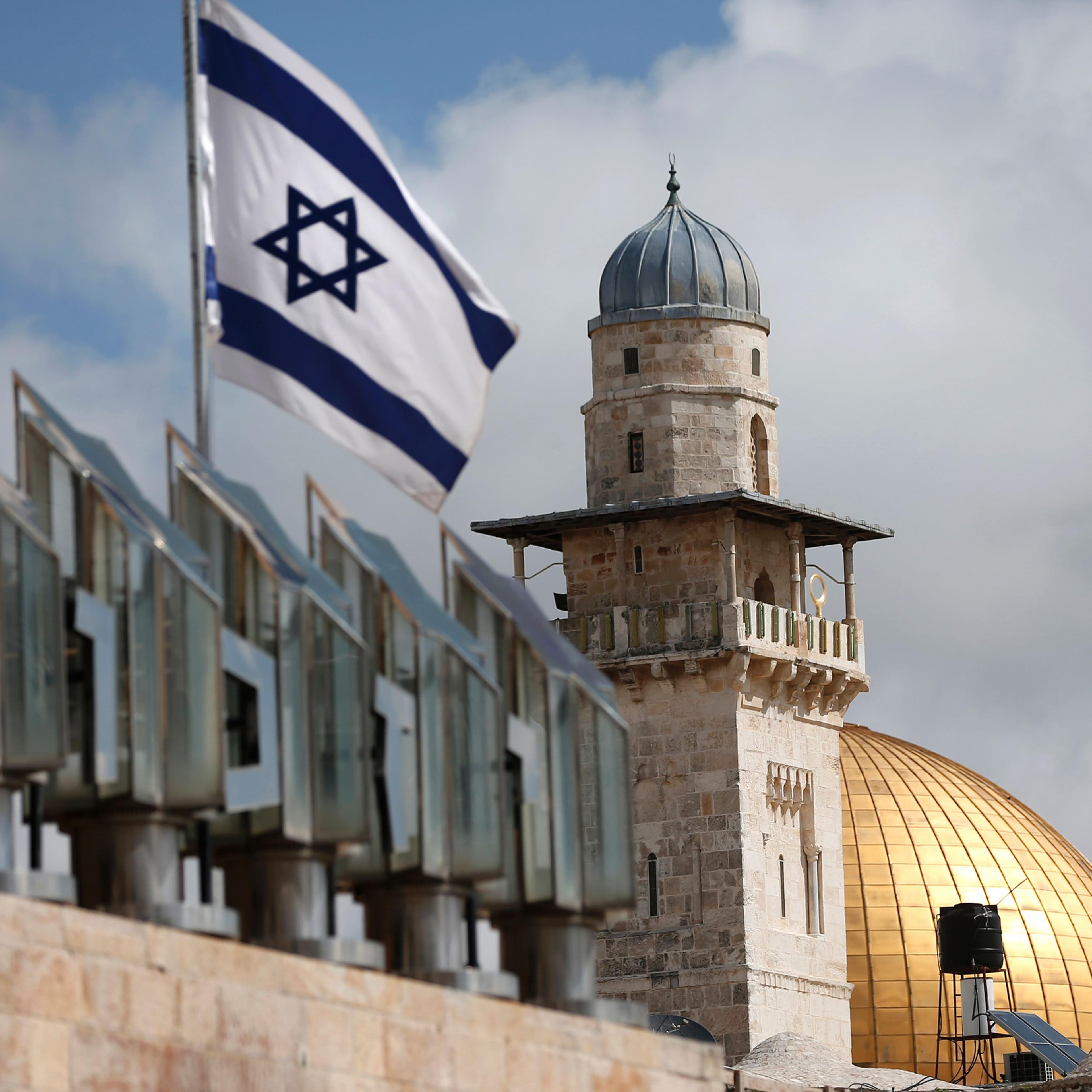 An Israeli flag is seen fleeting in front of a minaret and the Dome of the Rock on the Al-Aqsa mosque compound in Jerusalem's Old City, on March 17, 2016.
