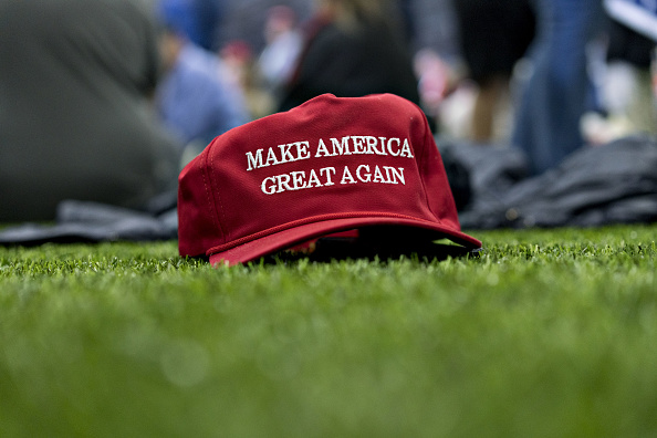 A 'Make America Great Again' hat sits on the ground ahead of a speech by U.S. President Donald Trump during a rally in Washington, Michigan, U.S., on Saturday, April 28, 2018.
