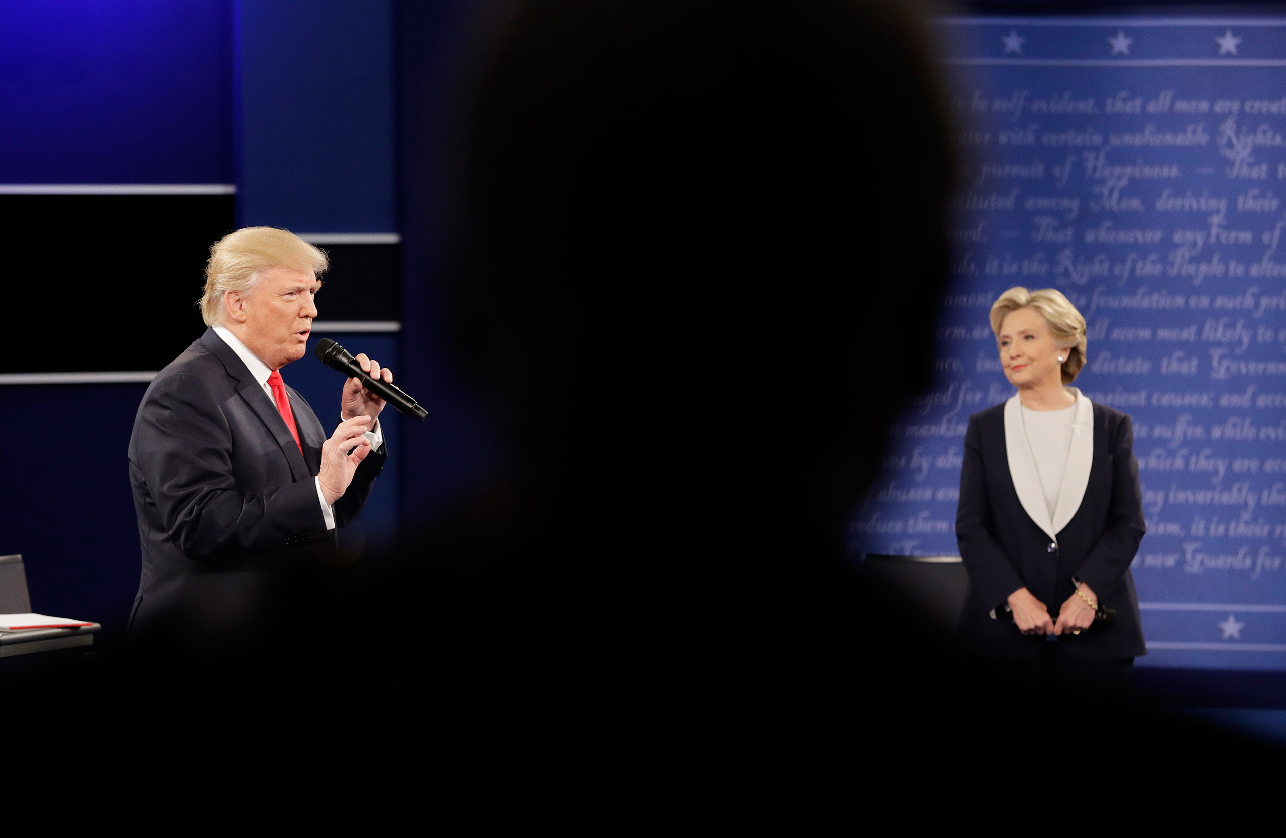 Republican presidential nominee Donald Trump speaks during the second debate as Democratic presidential nominee Hillary Clinton listens at Washington University in St. Louis on Oct. 9, 2016.