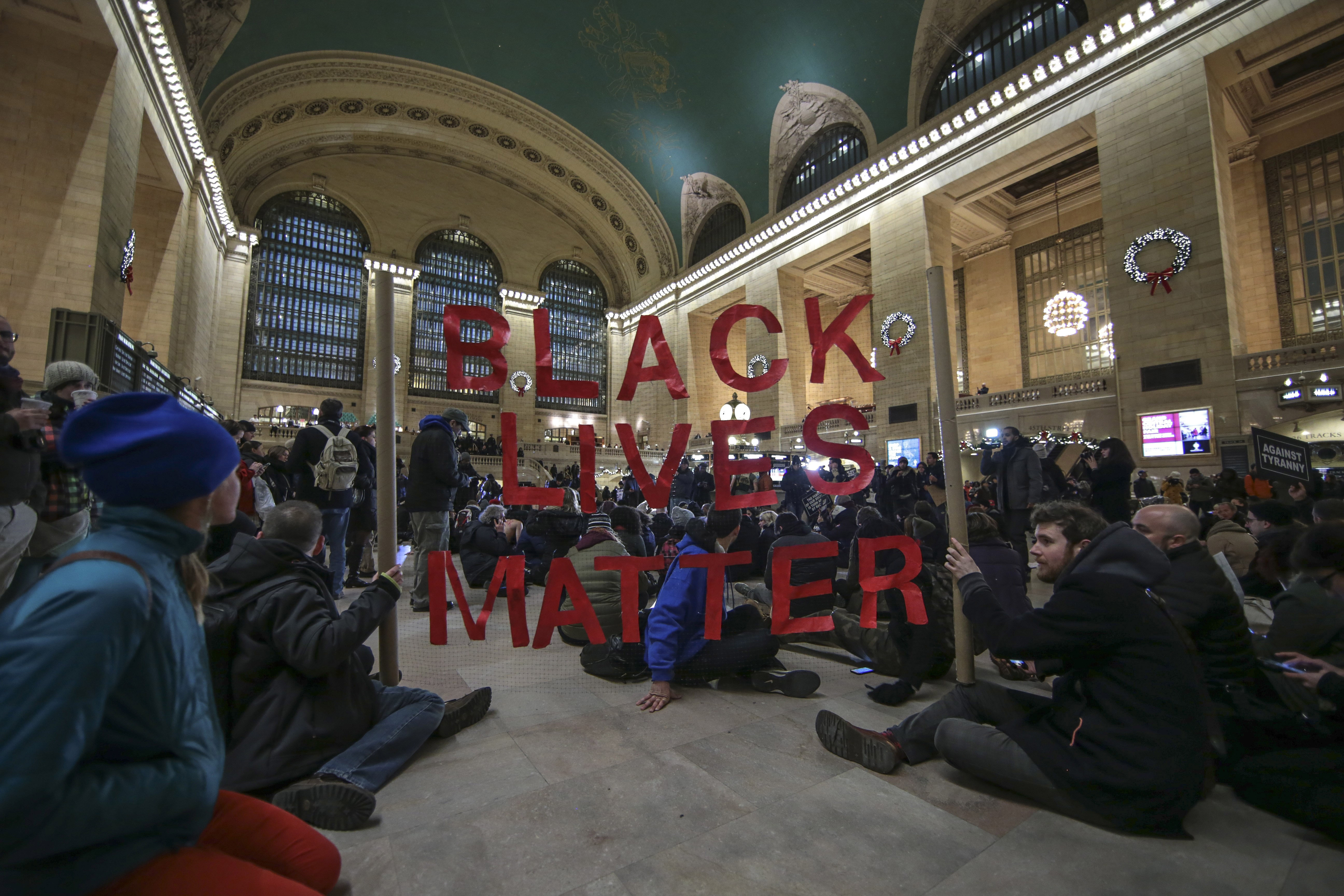 NEW YORK, NY - DECEMBER 7: Protesters hold a banner during a protest at Grand Central Terminal after a grand jury decided not to indict a police officer involved in the death of  Eric Garner in July on December 7, 2014 in New York, N.Y. Protests are bein