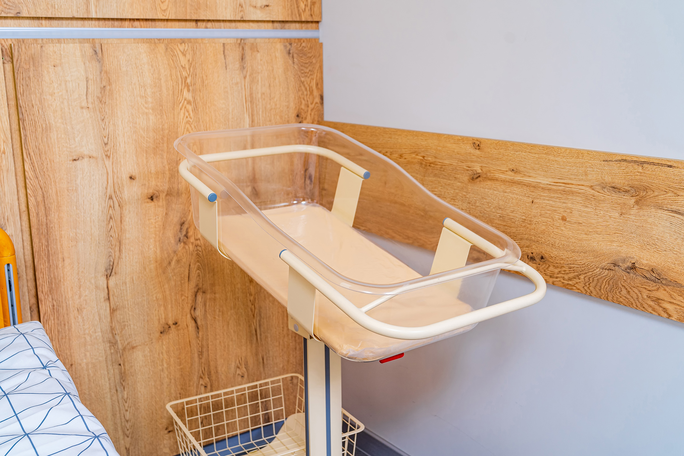 Closeup of an empty baby cradle in the postpartum ward of a hospital.