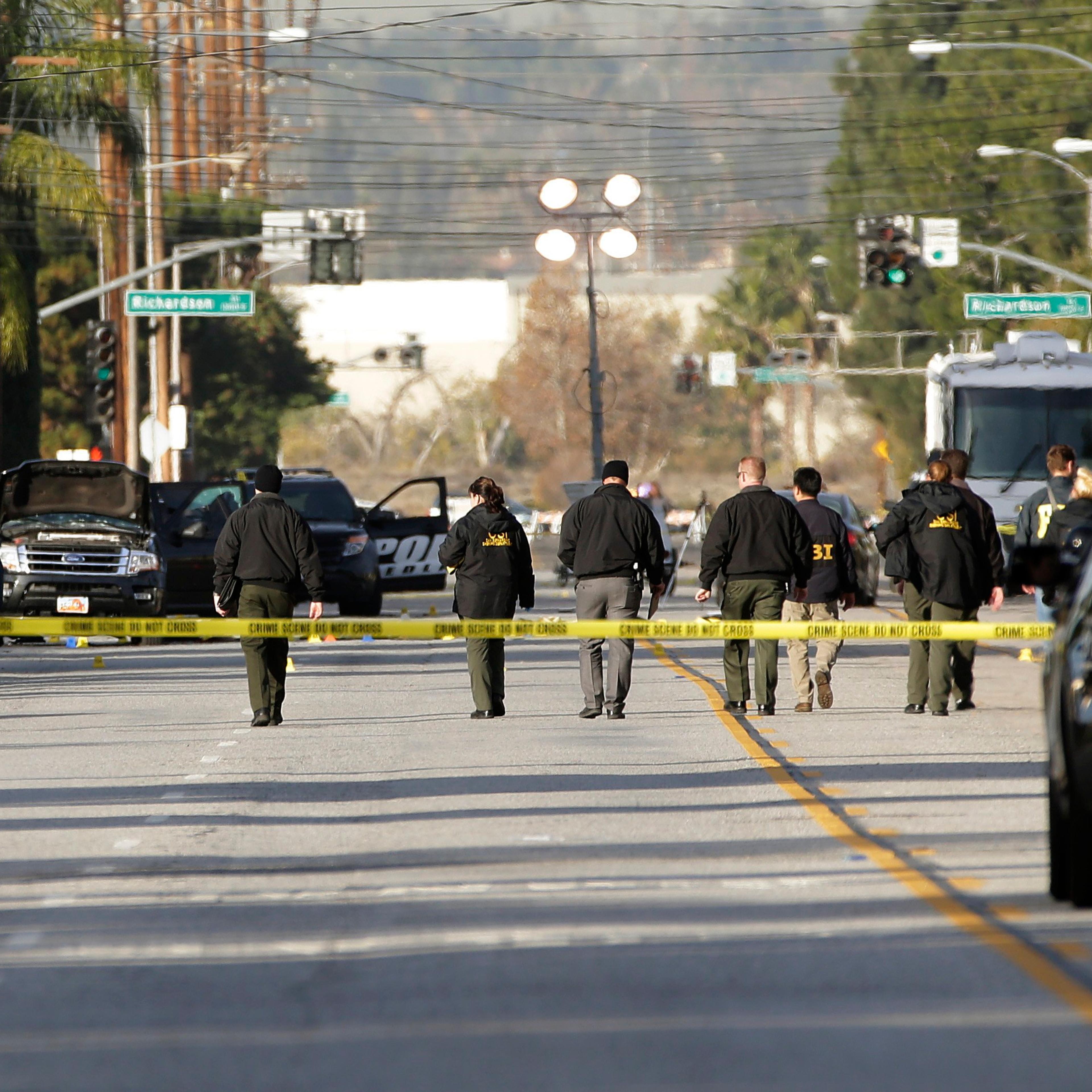 Investigators search for bullet casings at the scene where Wednesday's police shootout with suspects took place in San Bernardino, Calif on Dec. 3, 2015.