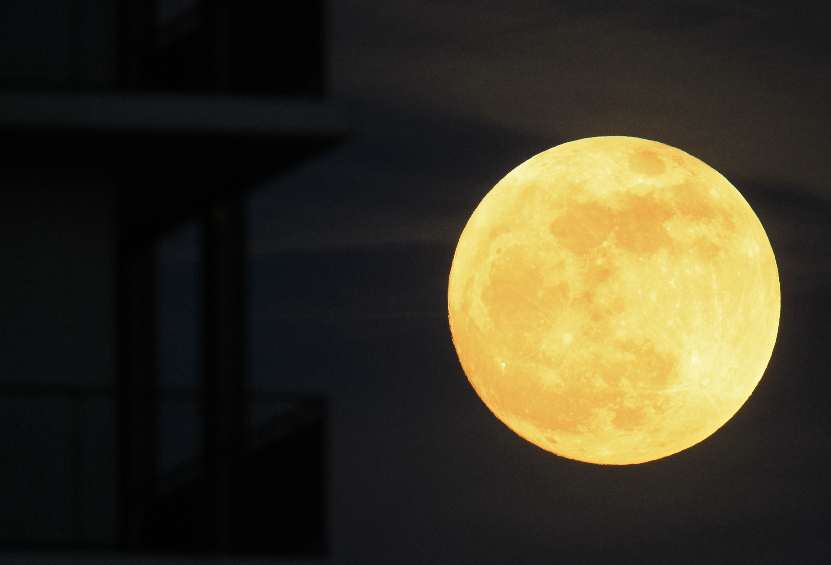 The moon rises near an apartment block in Bucharest on May 5, 2012.
