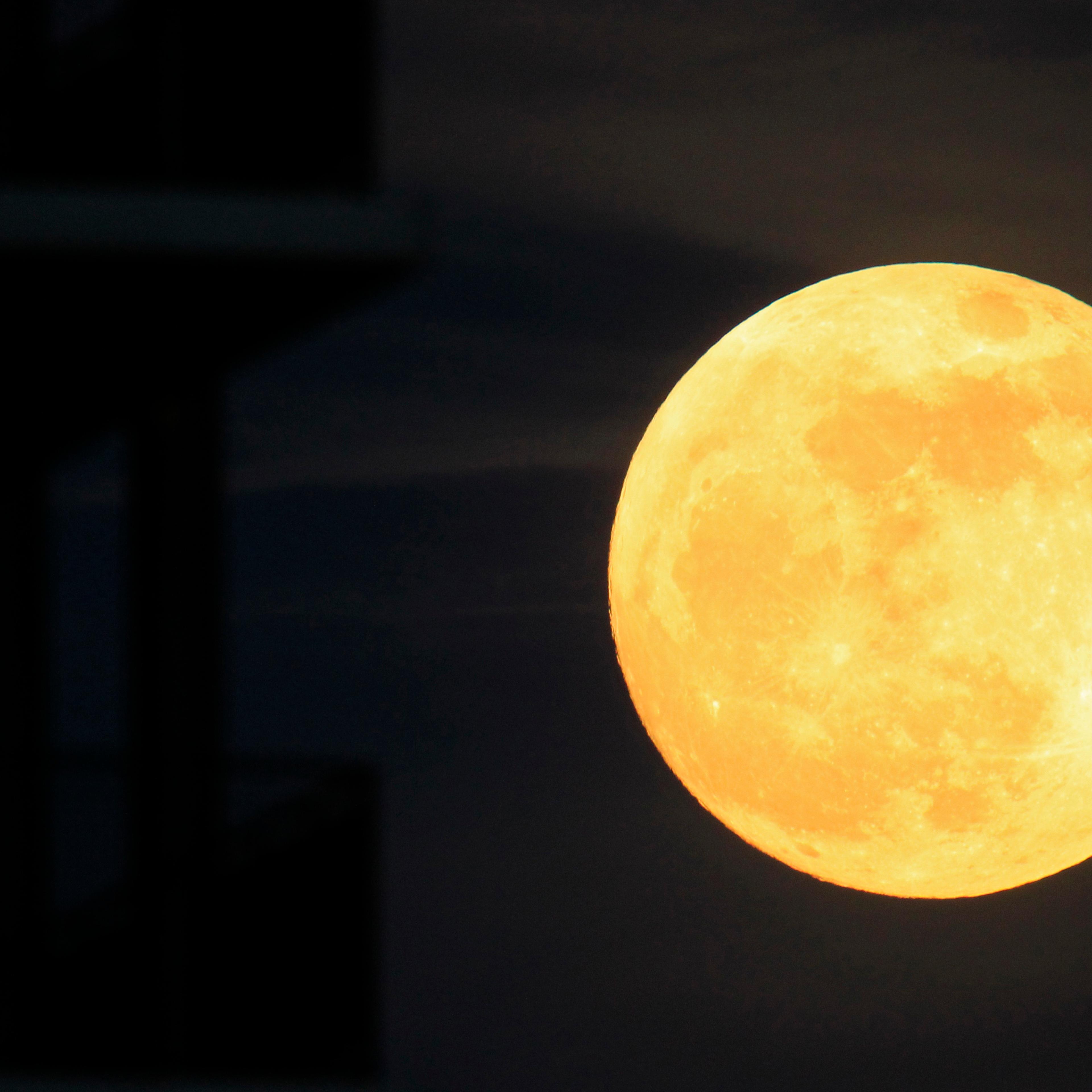 The moon rises near an apartment block in Bucharest on May 5, 2012.