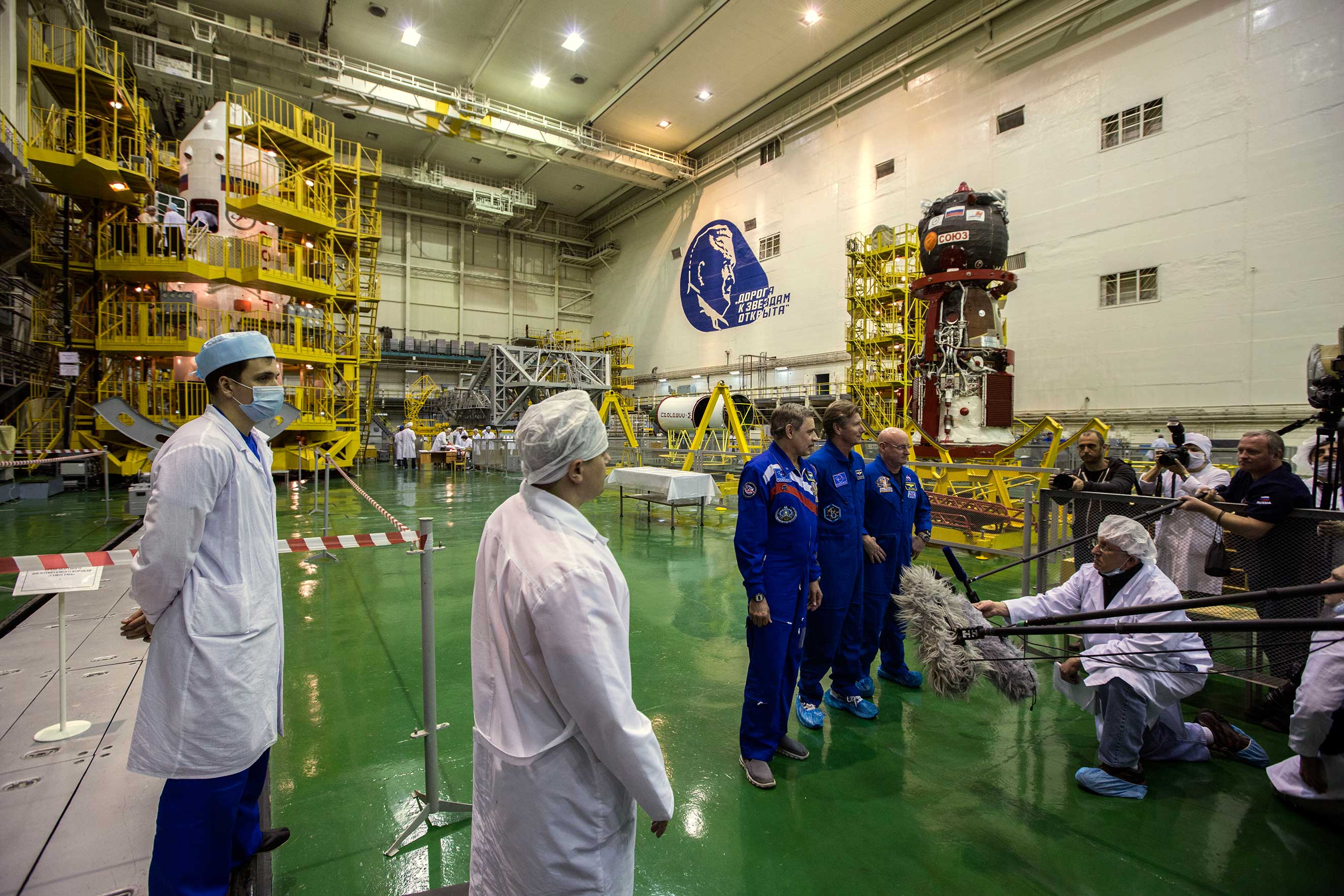 Members of the press and officials from NASA and Roscosmos talk with Russian Cosmonauts Mikhail Kornienko and Gennady Padalka, alongside NASA Astronaut Scott Kelly, after a training session at the Baikonur Cosmodrome in Kazakhstan on Monday, March 23, 20