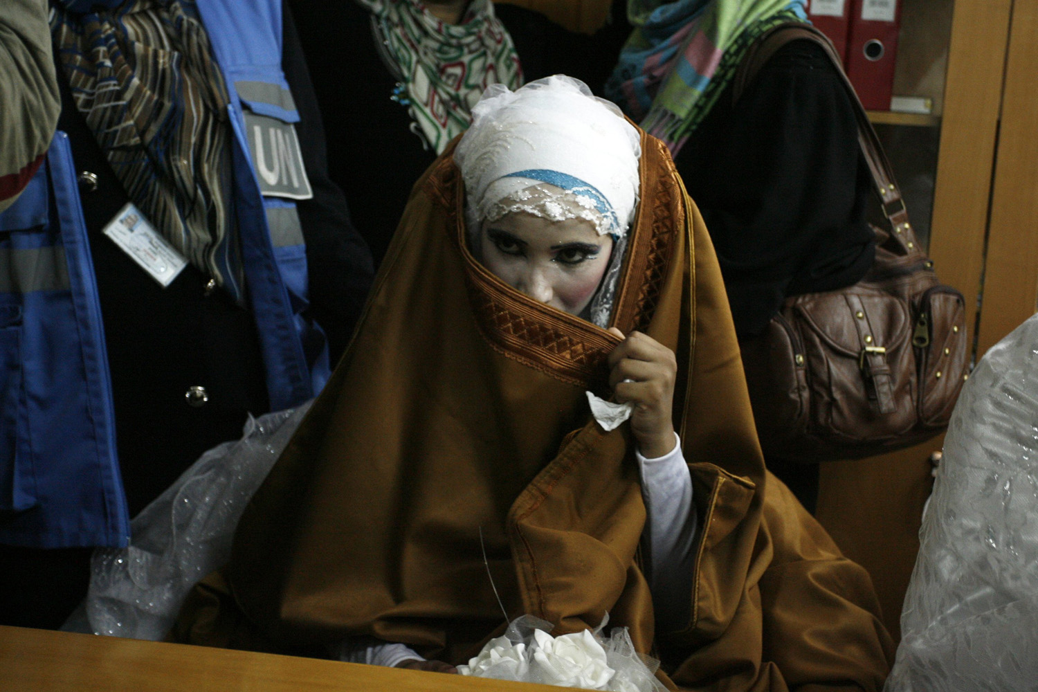 A PALESTINIAN BRIDE, WHO LOST HER HOME DURING FIGHTING BETWEEN HAMAS AND ISRAEL, POSES DURING HER WEDDING CEREMONY, ALONG WITH TWO OTHER COUPLES, AT A UN SCHOOL