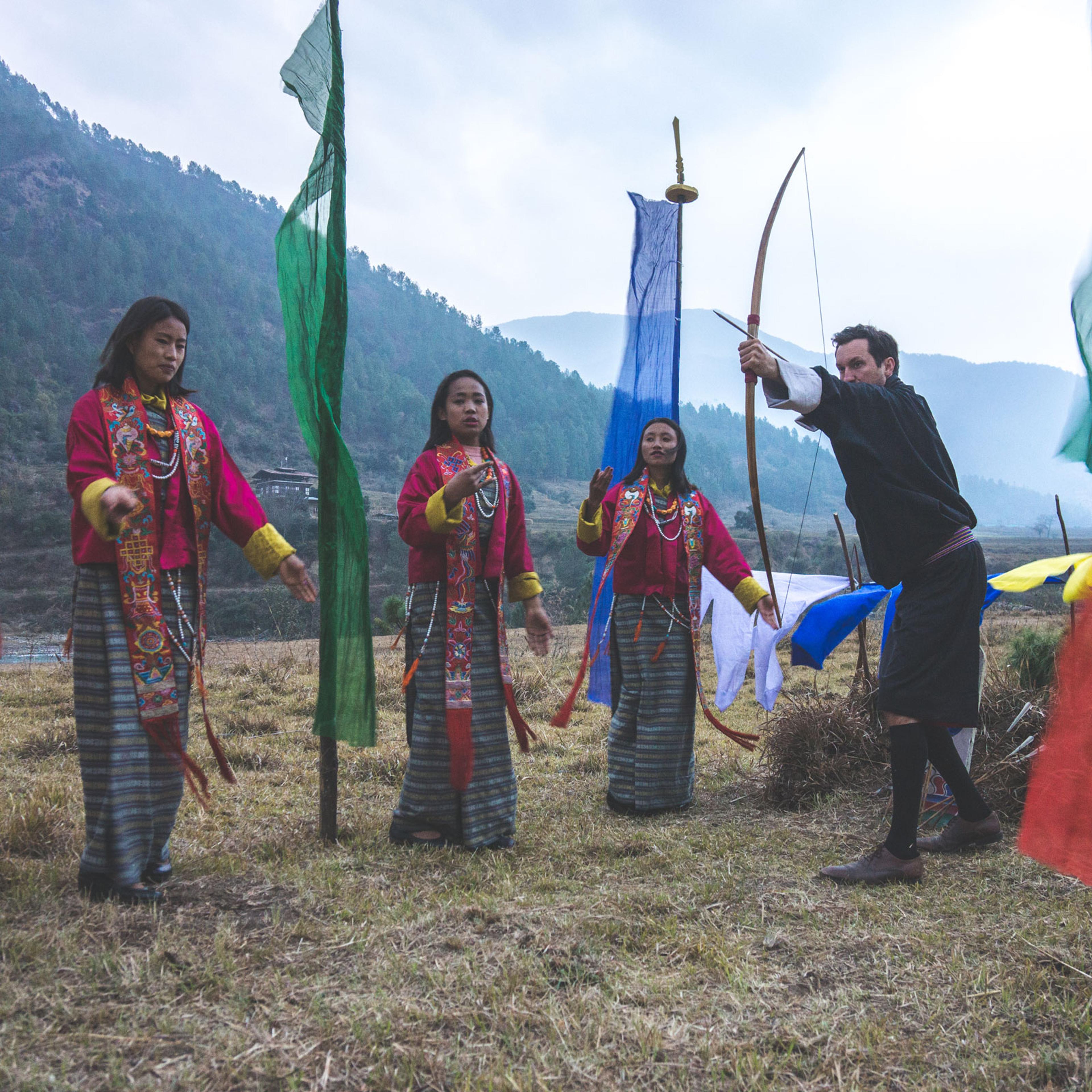 A man holds a bow and arrow at Sangwa Camp
