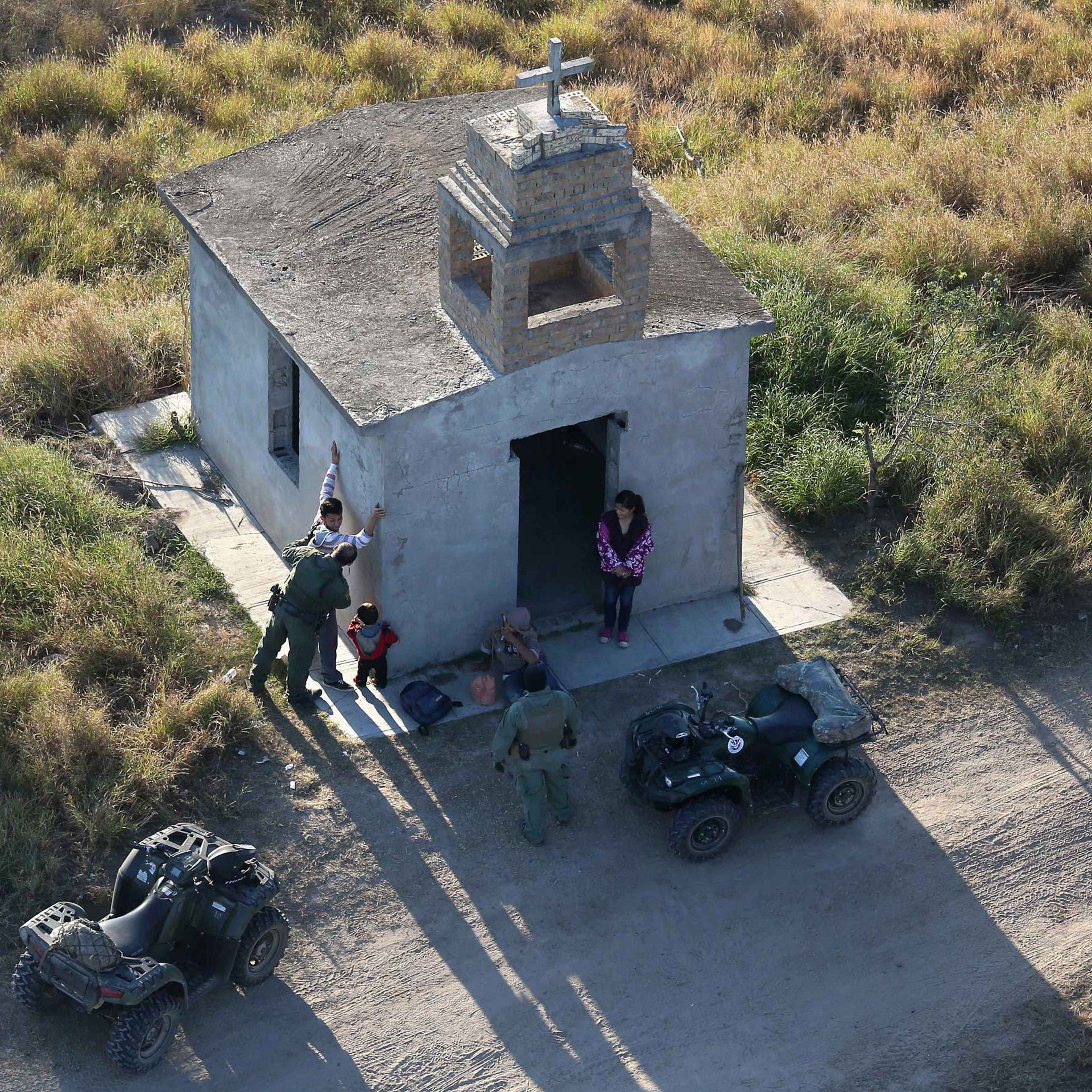 U.S. Border Patrol agents search a migrant family after they crossed the U.S.-Mexico border near Rio Grande City, Texas, on Dec. 9, 2015.