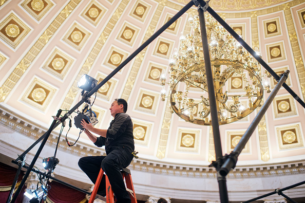 A worker installs lights in the Capitol's Statuary Hall in preparation for State of the Union address, January 12, 2016.
