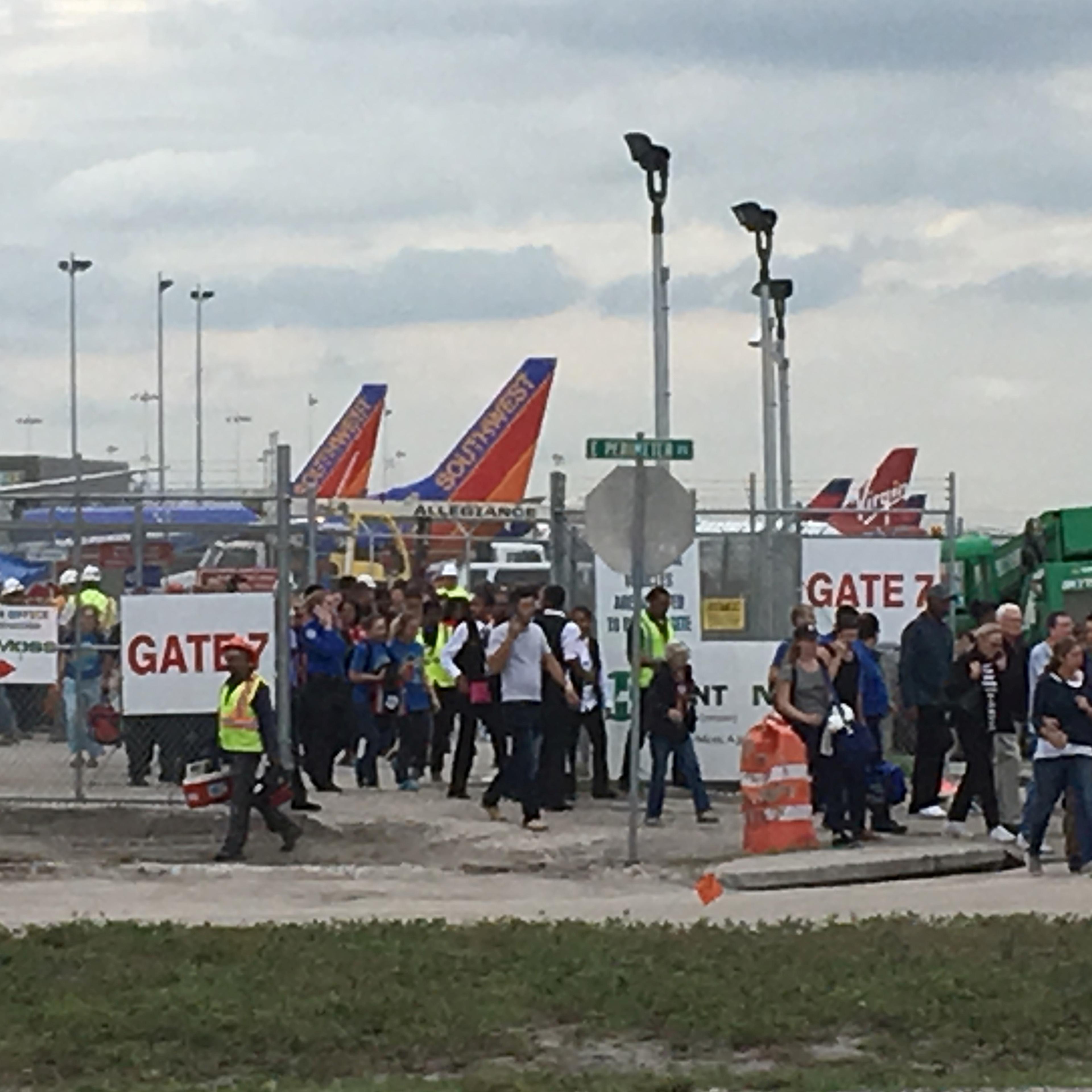Travelers and airport workers are evacuated out of the terminal after airport shooting at Fort Lauderdale-Hollywood International Airport in Florida, Jan. 6, 2017.
