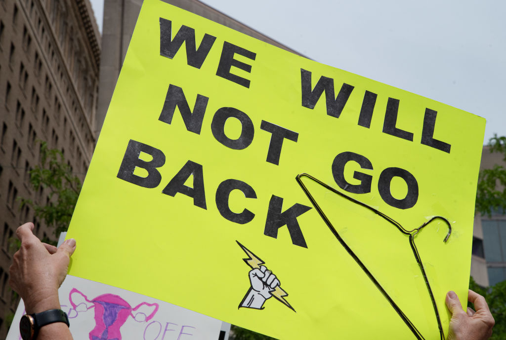 A protester holds a placard that says "We will not go back"