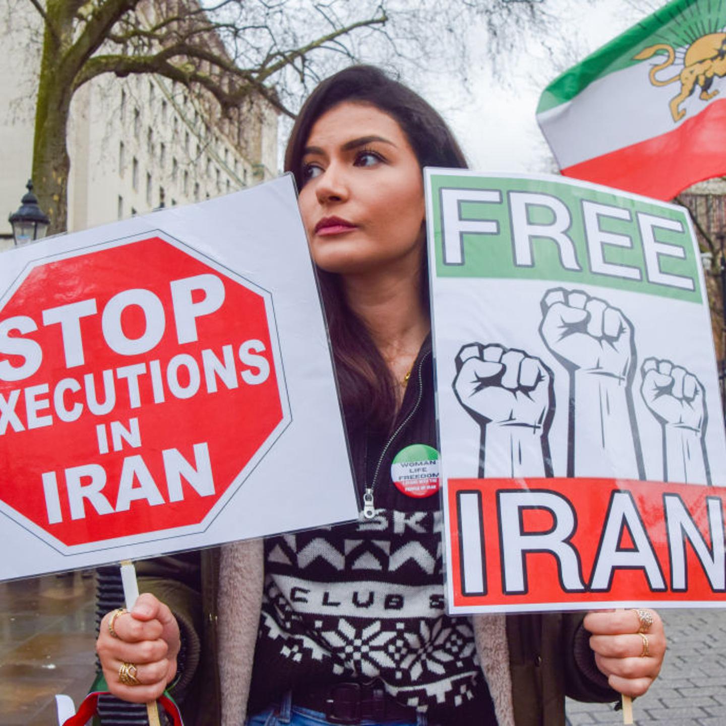 A protester holds 'Stop executions in Iran' and 'Free Iran'