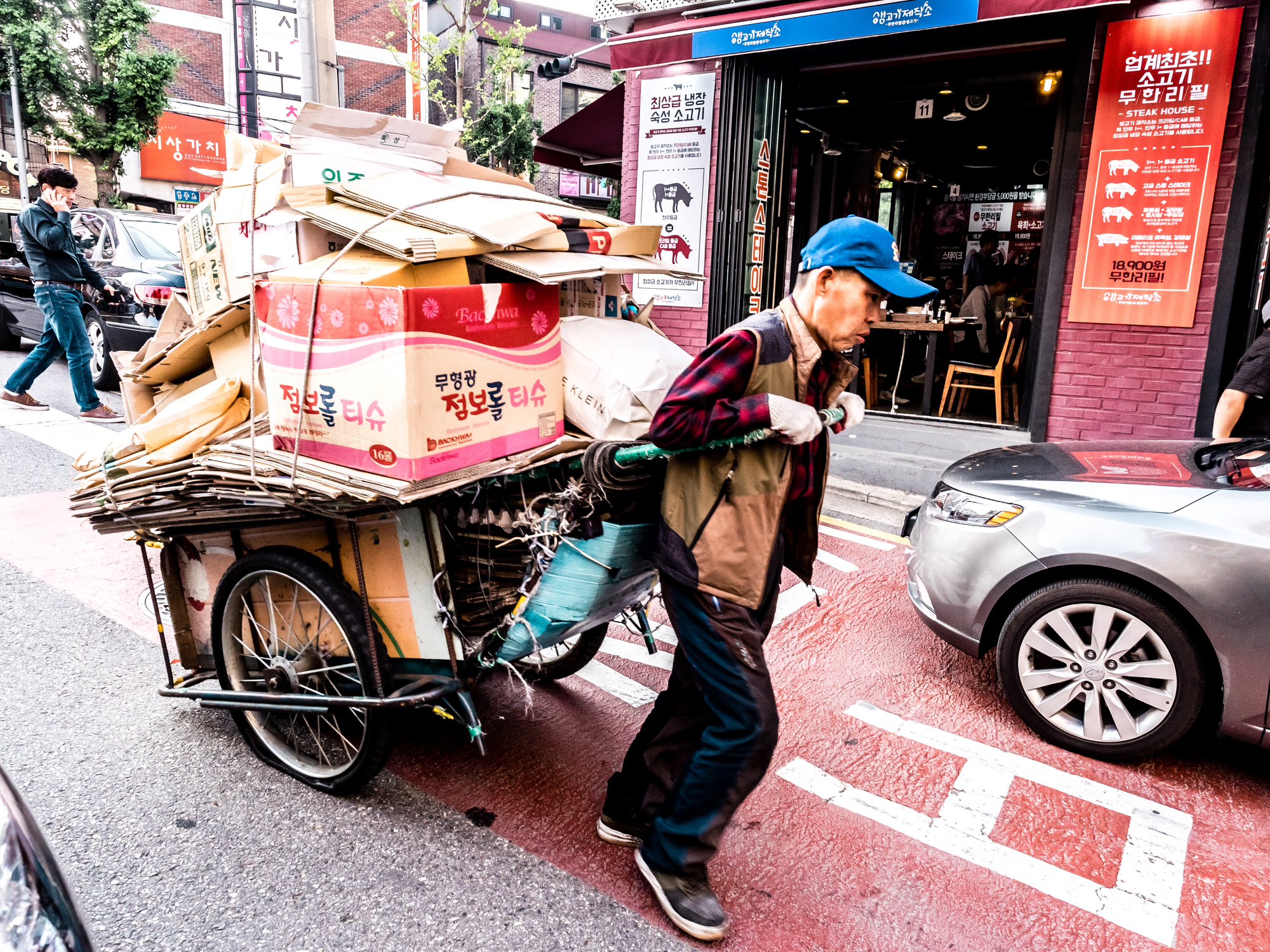 An elderly man carrying a cart with cardboard in downtown Seoul on June 8, 2017.