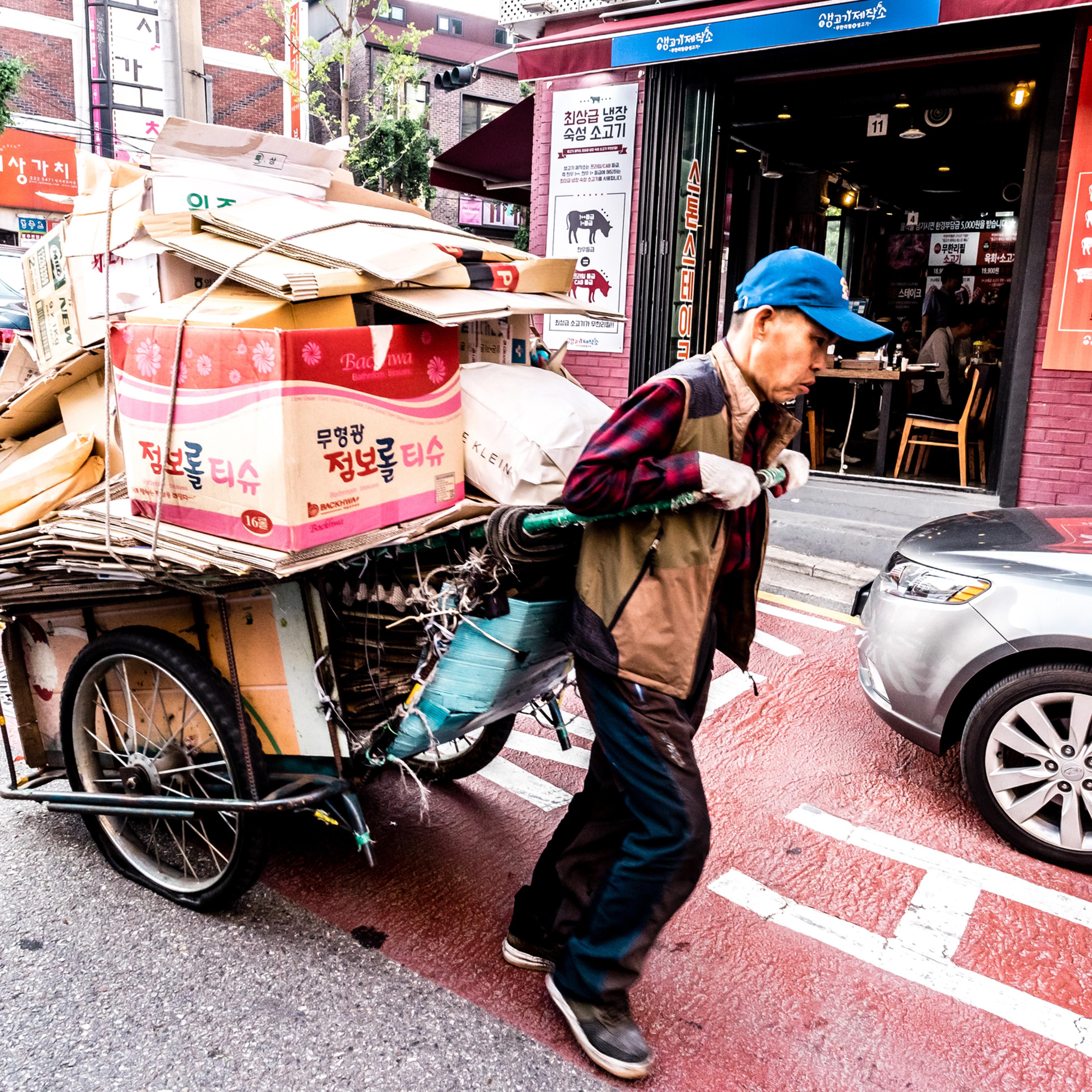 An elderly man carrying a cart with cardboard in downtown Seoul on June 8, 2017.