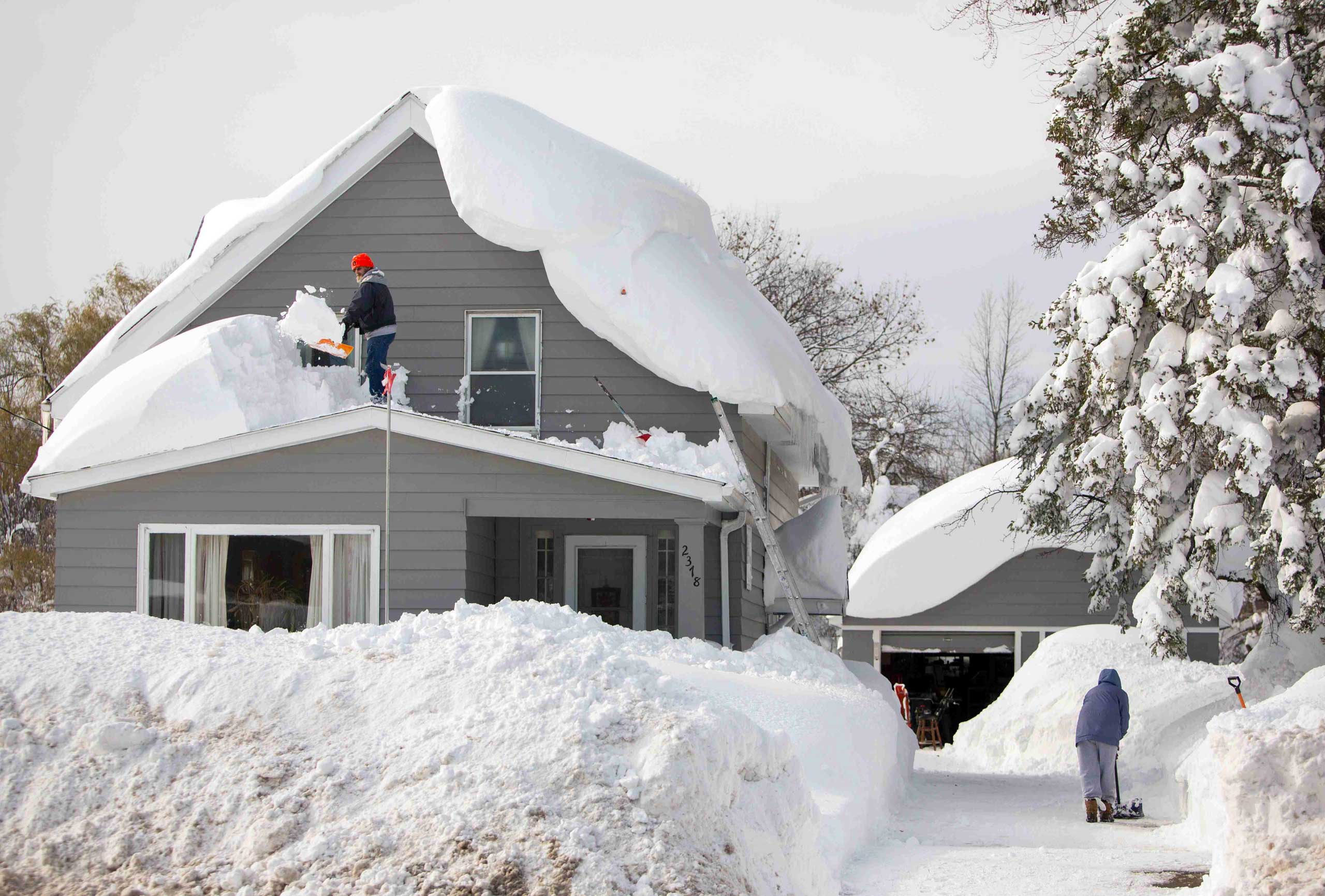 A man clears snow from his roof in the town of Cheektowaga near Buffalo, New York, Nov. 19, 2014.