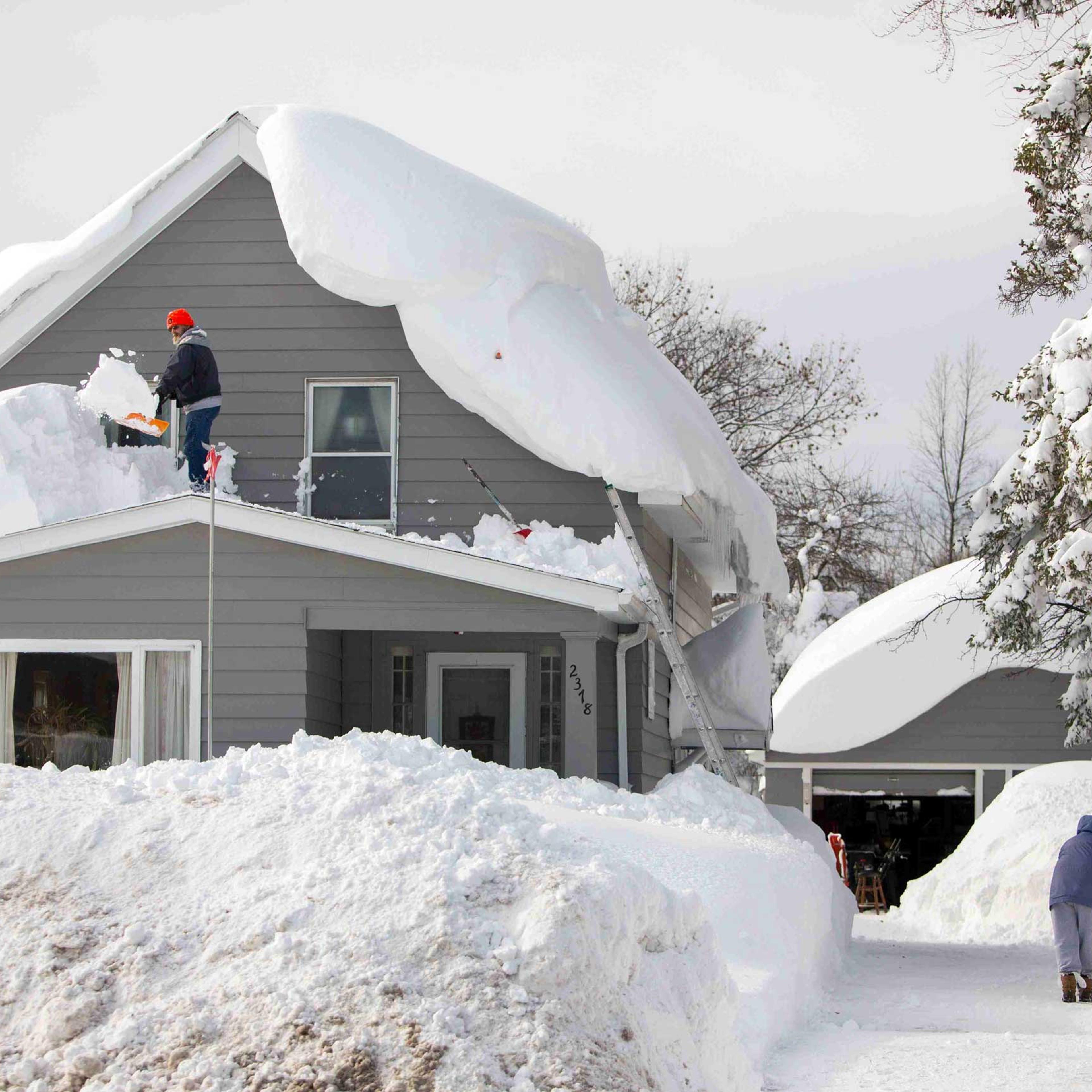 A man clears snow from his roof in the town of Cheektowaga near Buffalo, New York, Nov. 19, 2014.