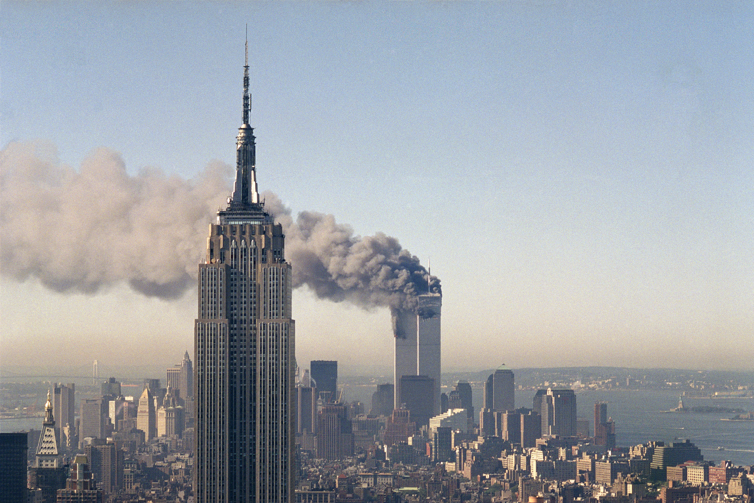 The twin towers of the World Trade Center burn behind the Empire State Building in New York after terrorists crashed two planes into the towers causing both to collapse, Sept. 11, 2001.