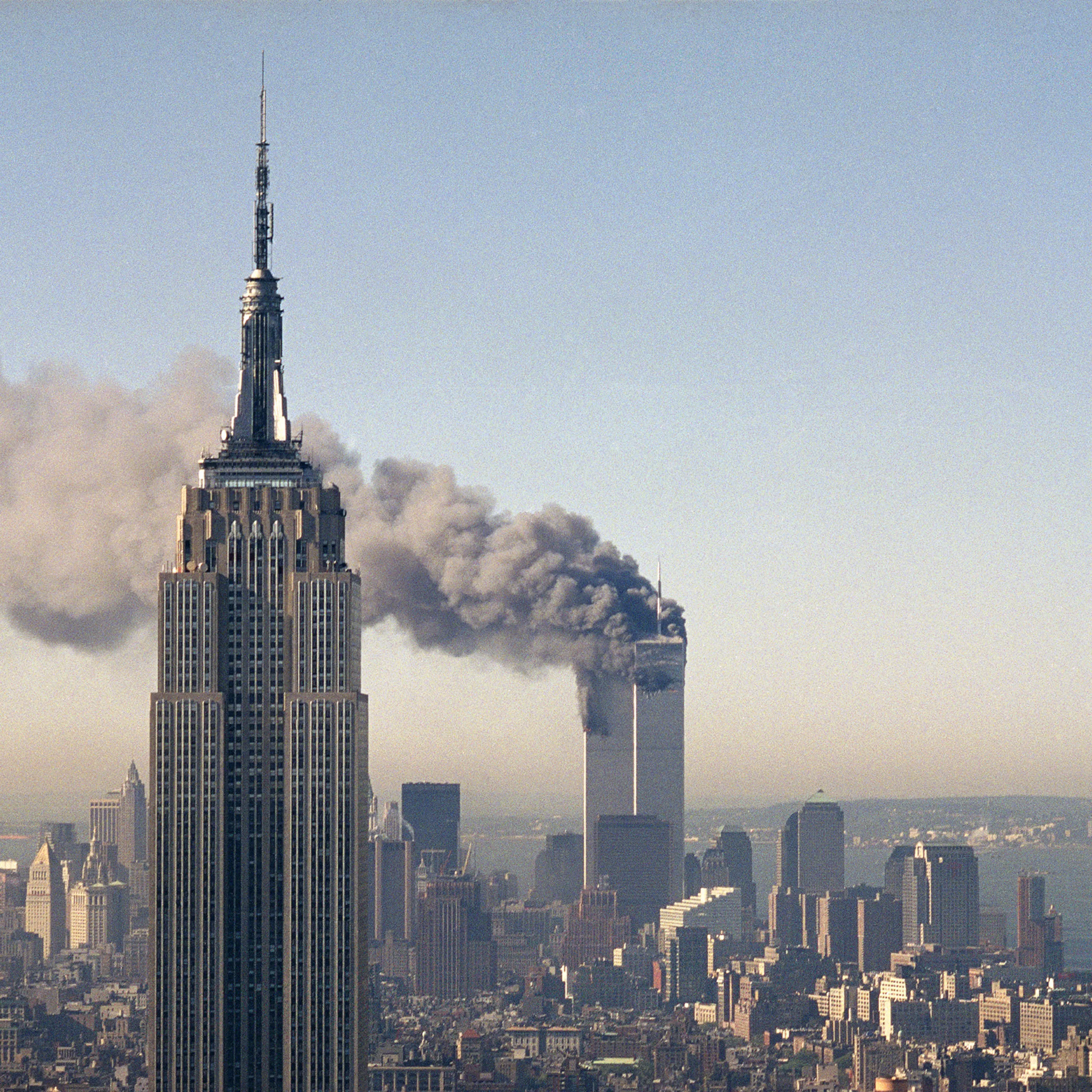 The twin towers of the World Trade Center burn behind the Empire State Building in New York after terrorists crashed two planes into the towers causing both to collapse, Sept. 11, 2001.