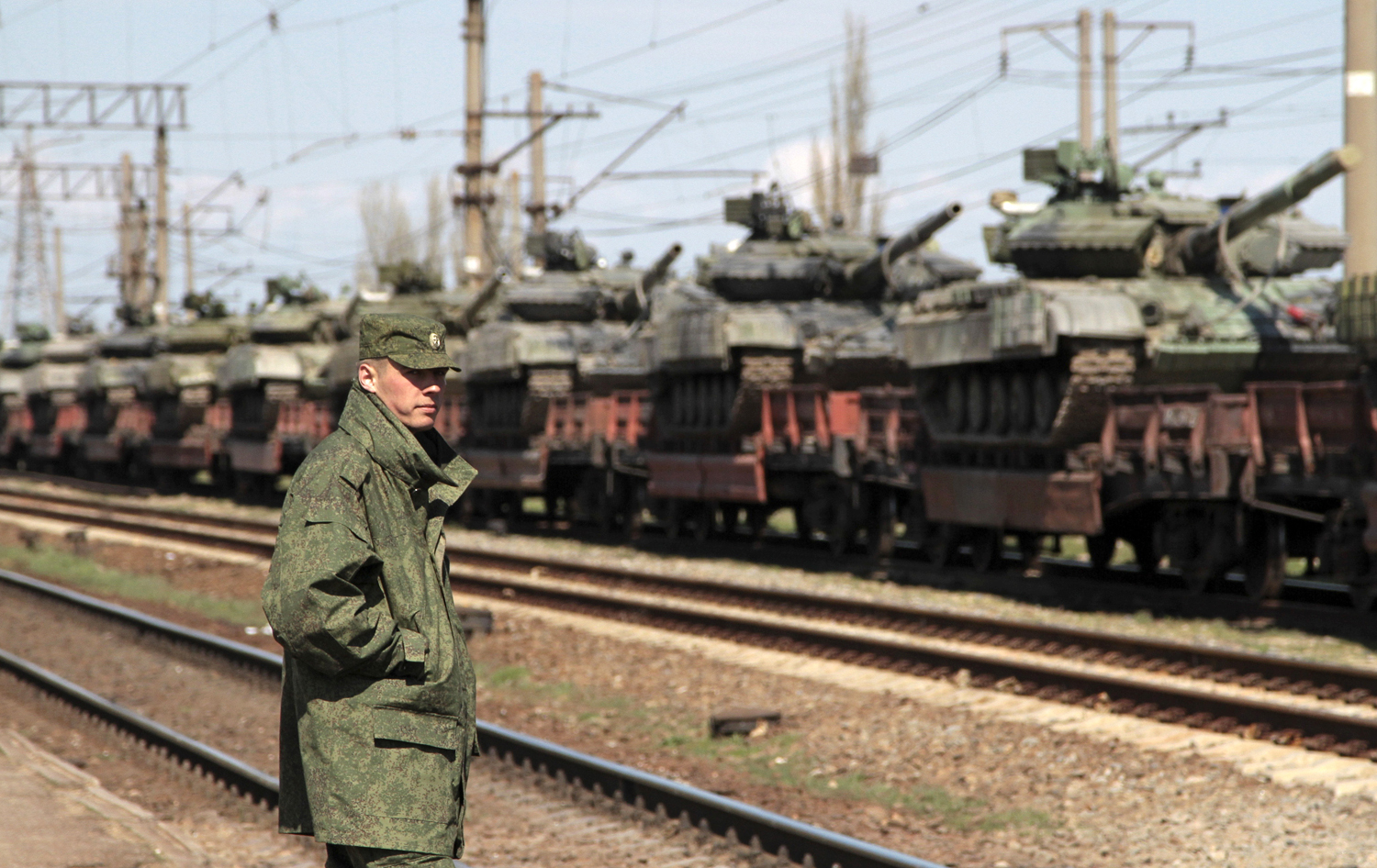 A Russian serviceman stands near Ukrainian tanks on freight cars before the departure from Crimea to other regions of Ukraine in the settlement of Gvardeiskoye near the Crimean city of Simferopol