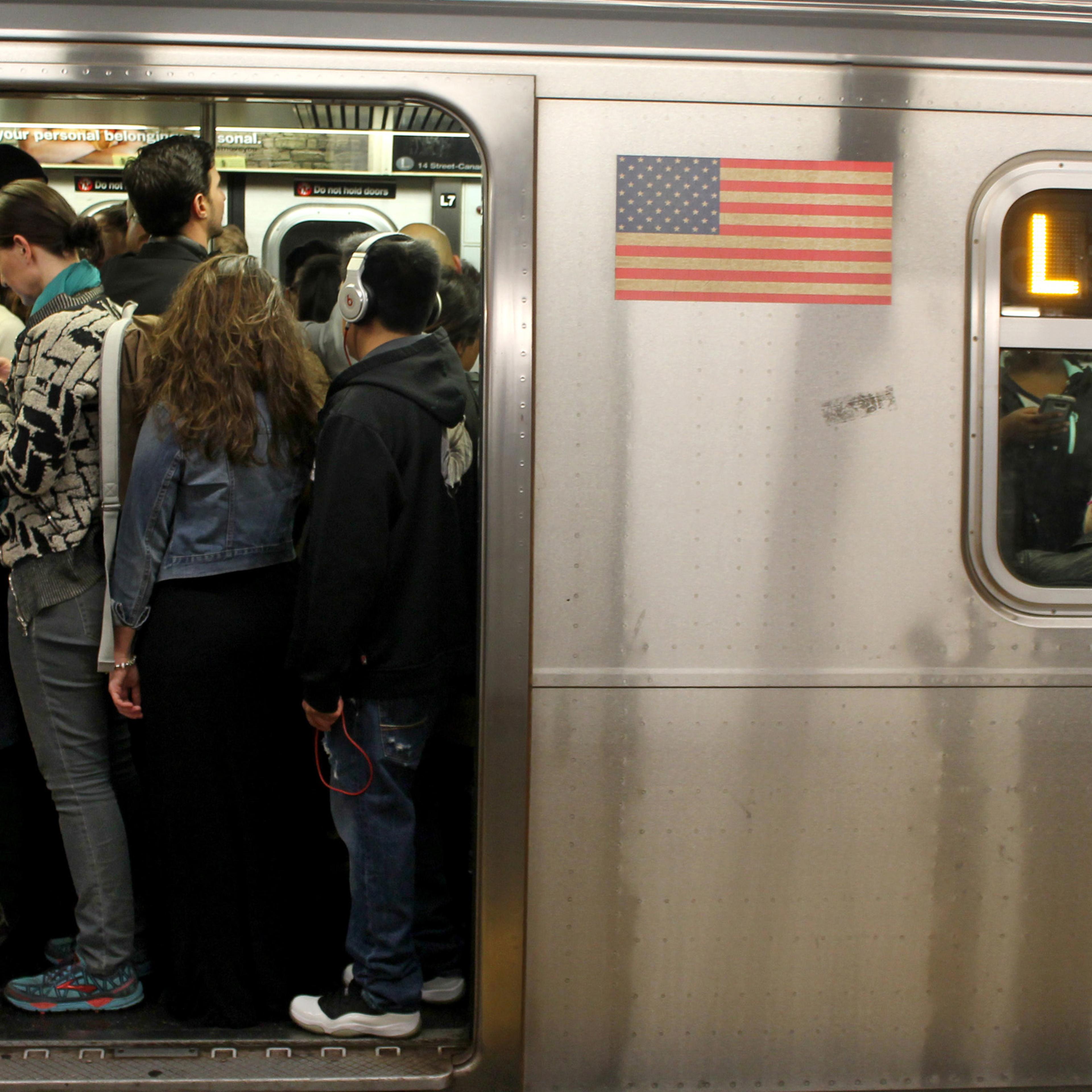 Passengers pack themselves into a crowded L Train on the New York City subway system on May 5, 2016.