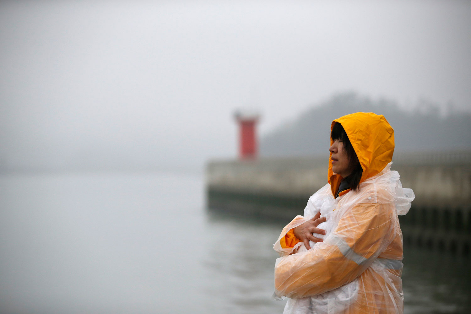 A family member of a passenger onboard the capsized South Korean ferry Sewol closes her eyes at a port where family members gathered to wait for news from the rescue team in Jindo April 18, 2014.