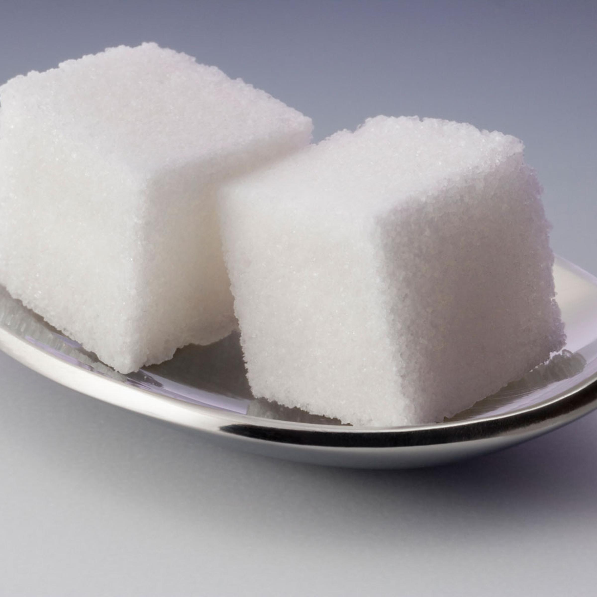 Two sugar cubes on spoon, close-up (still life)