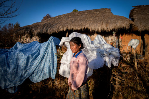 Galau Dau Yang, 35, stands outside her home in the northern Shan State village of Kut Khaing. Galau Dau Yang, who is ethnically Kachin, was gang-raped by police. Like in most conflict zones, human rights organizations report that rape is being used as a weapon by the military and police in Kachin State and neighboring Shan State, where many of the refugees have fled
