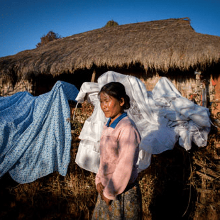 Galau Dau Yang, 35, stands outside her home in the northern Shan State village of Kut Khaing. Galau Dau Yang, who is ethnically Kachin, was gang-raped by police. Like in most conflict zones, human rights organizations report that rape is being used as a weapon by the military and police in Kachin State and neighboring Shan State, where many of the refugees have fled