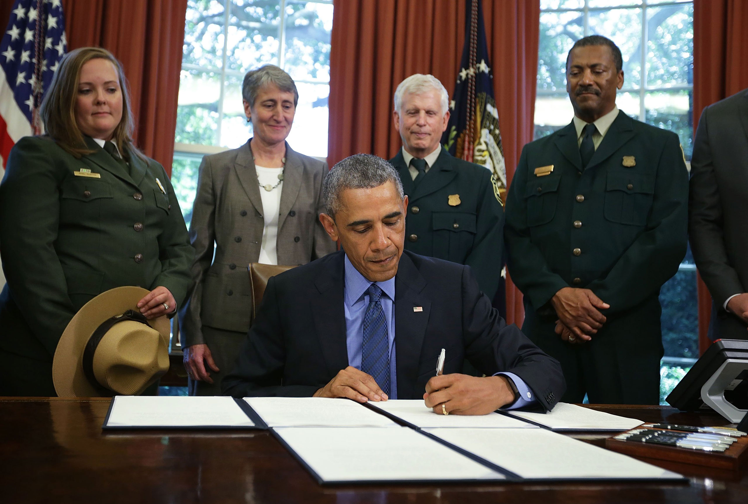 President Barack Obama signs proclamations to designate three new national monuments as Secretary of Interior Sally Jewell (2nd L) looks on in the Oval Office of the White House July 10, 2015 in Washington, DC. President Obama has designated three new na