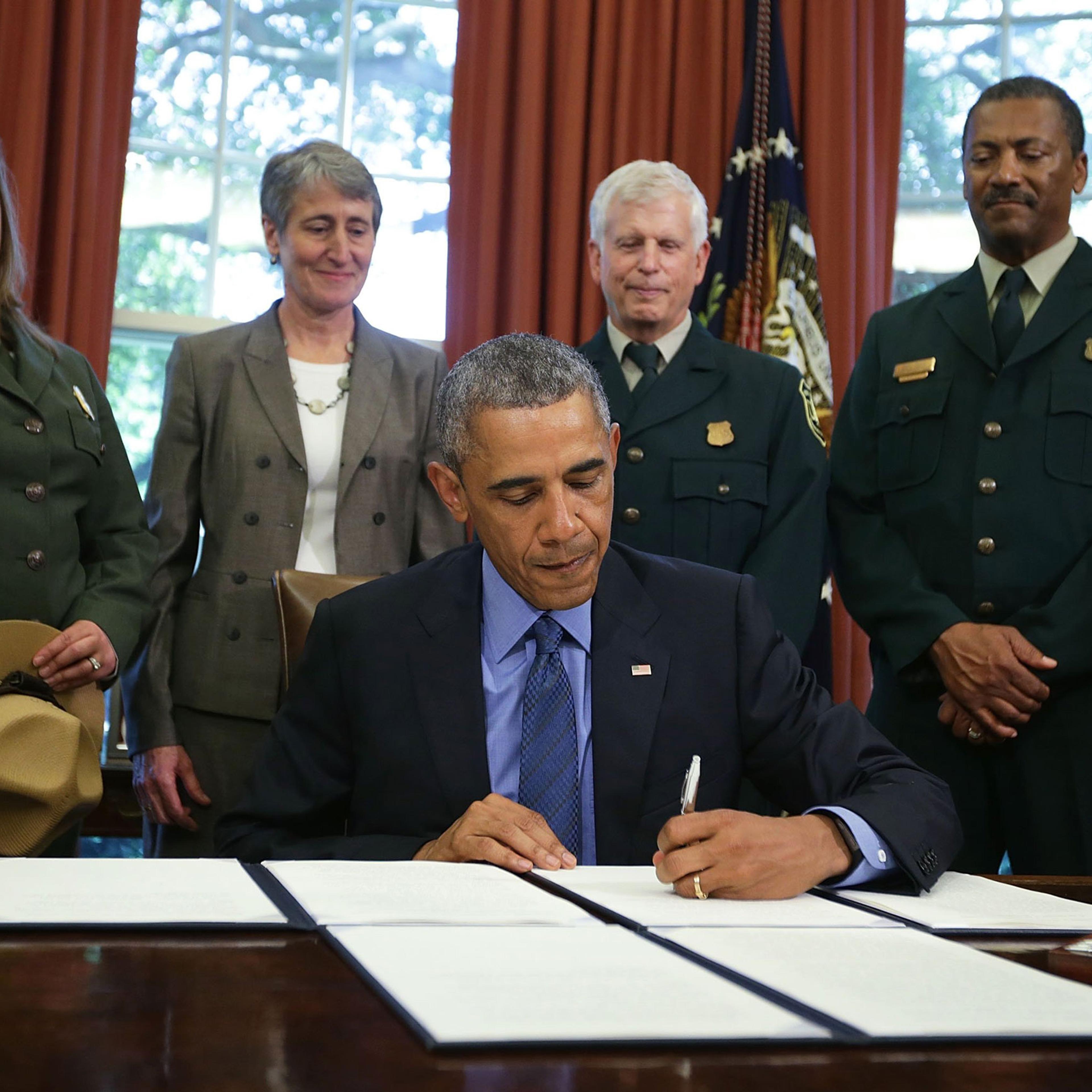 President Barack Obama signs proclamations to designate three new national monuments as Secretary of Interior Sally Jewell (2nd L) looks on in the Oval Office of the White House July 10, 2015 in Washington, DC. President Obama has designated three new na