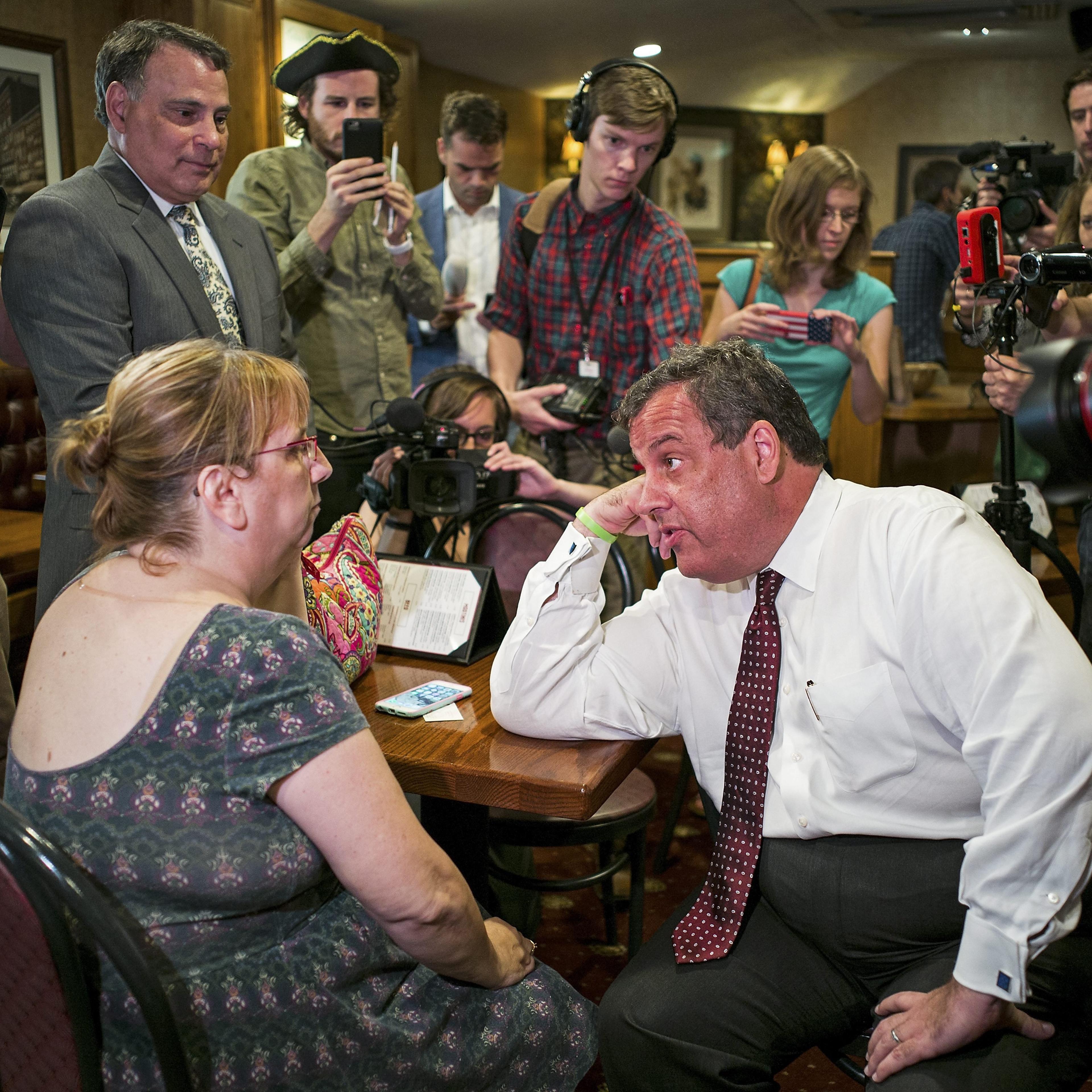 Chris Christie, Governor of New Jersey and candidate in the Republicans' presidential candidates race, talks with a voter at The Puritan Backroom in Manchester, N.H. on Aug. 3, 2015.