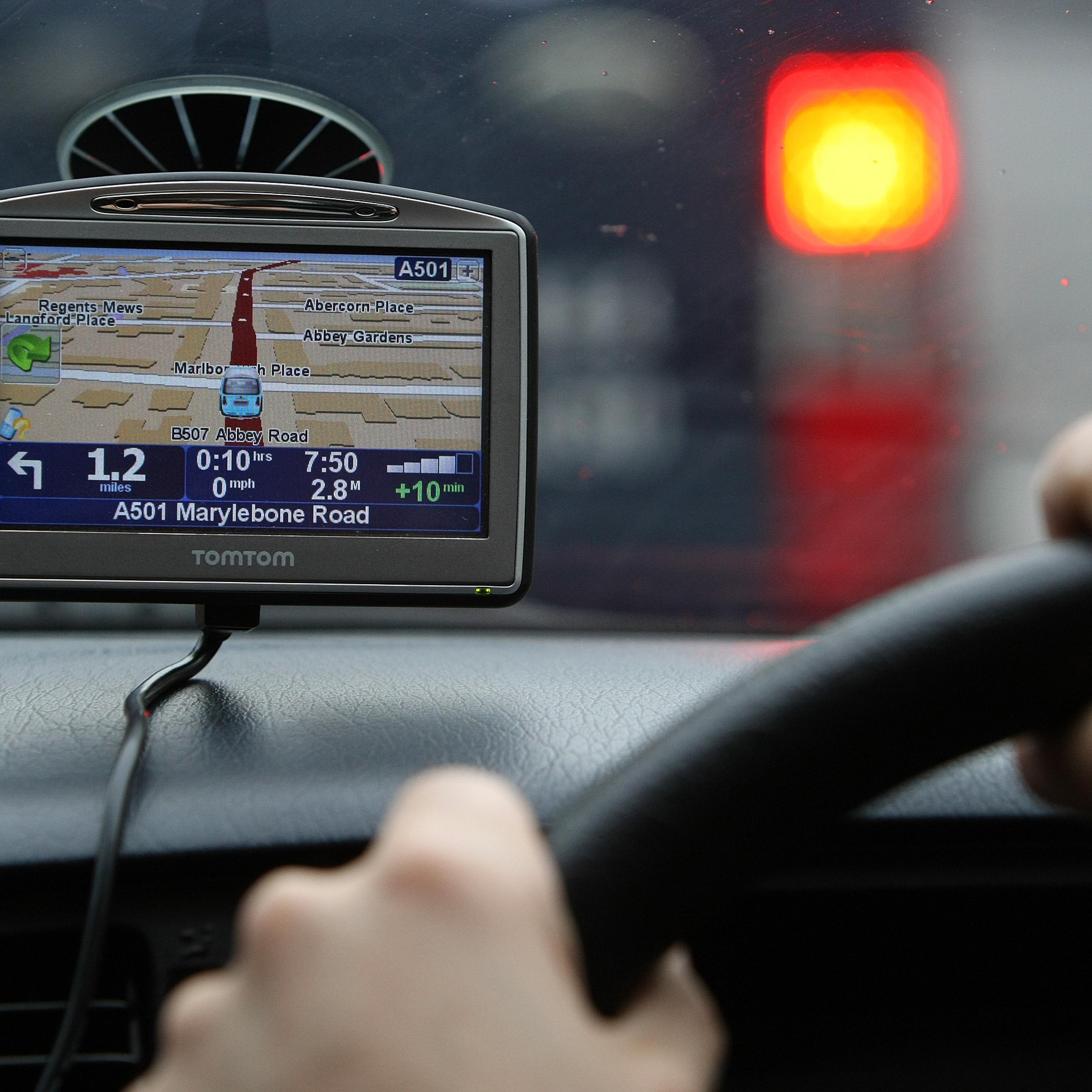 A driver uses a Tom Tom navigation device in central London,