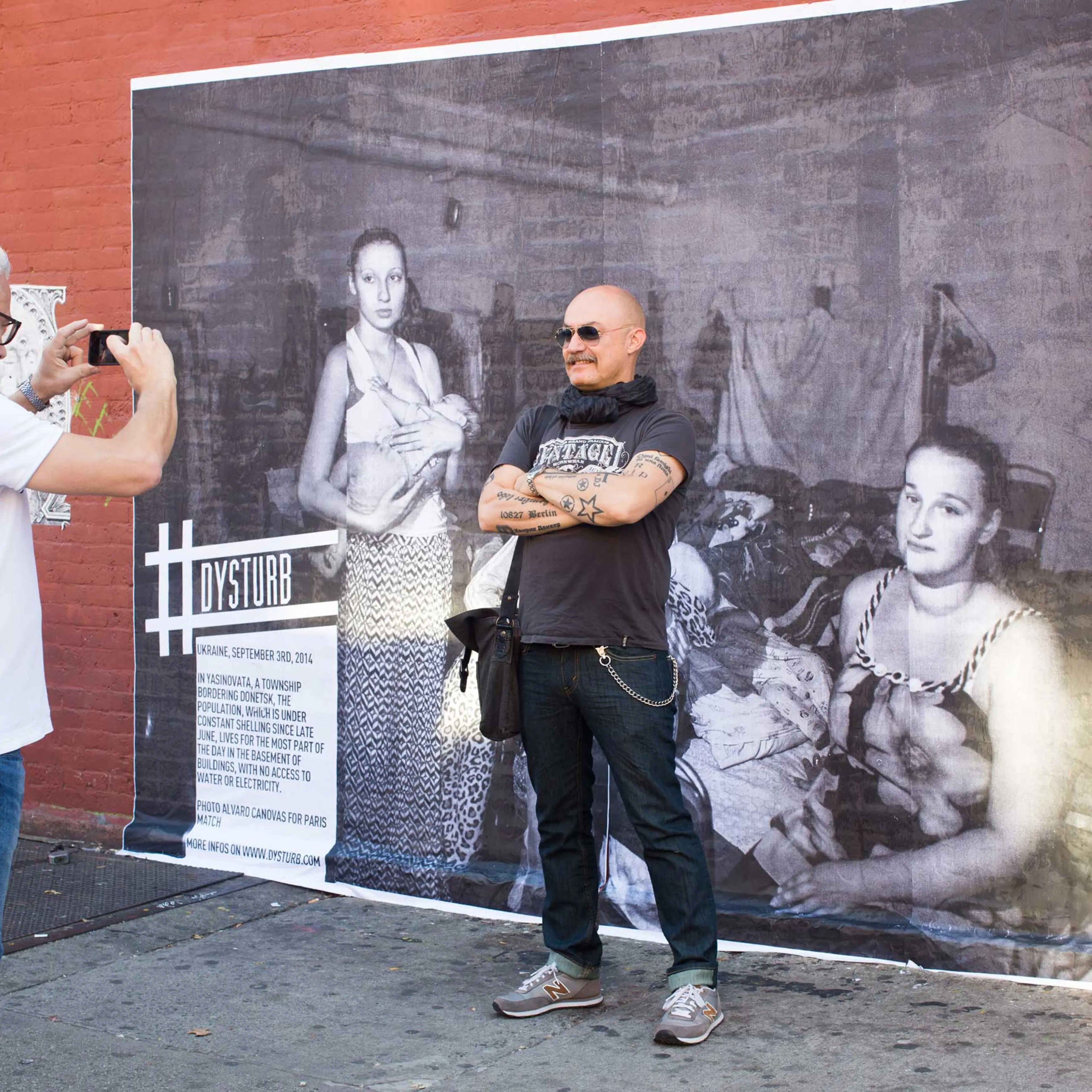 A New Yorker in front of one of Dysturb's photographs (in Brooklyn, on the corner of N 6th Street and Bedford Avenue). October 17th 2014.