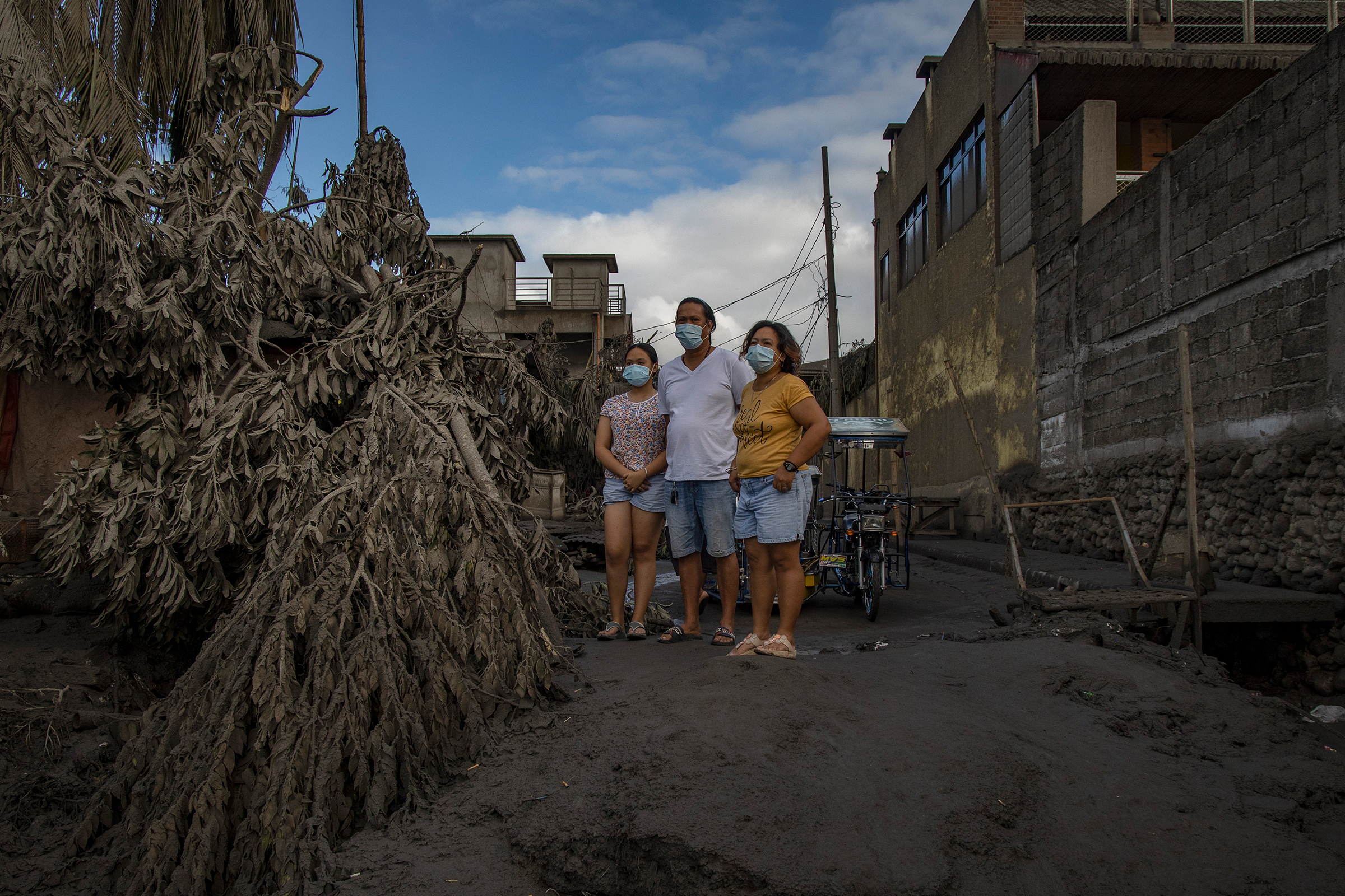 Residents return to their homes covered in ash in Talisay on Jan. 14.