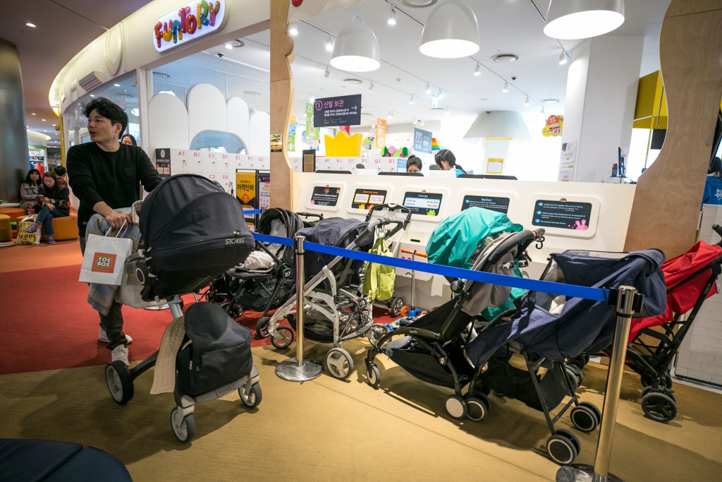 Baby strollers are parked outside a kids cafe inside a shopping mall on March 9, 2019 in Seoul, South Korea.