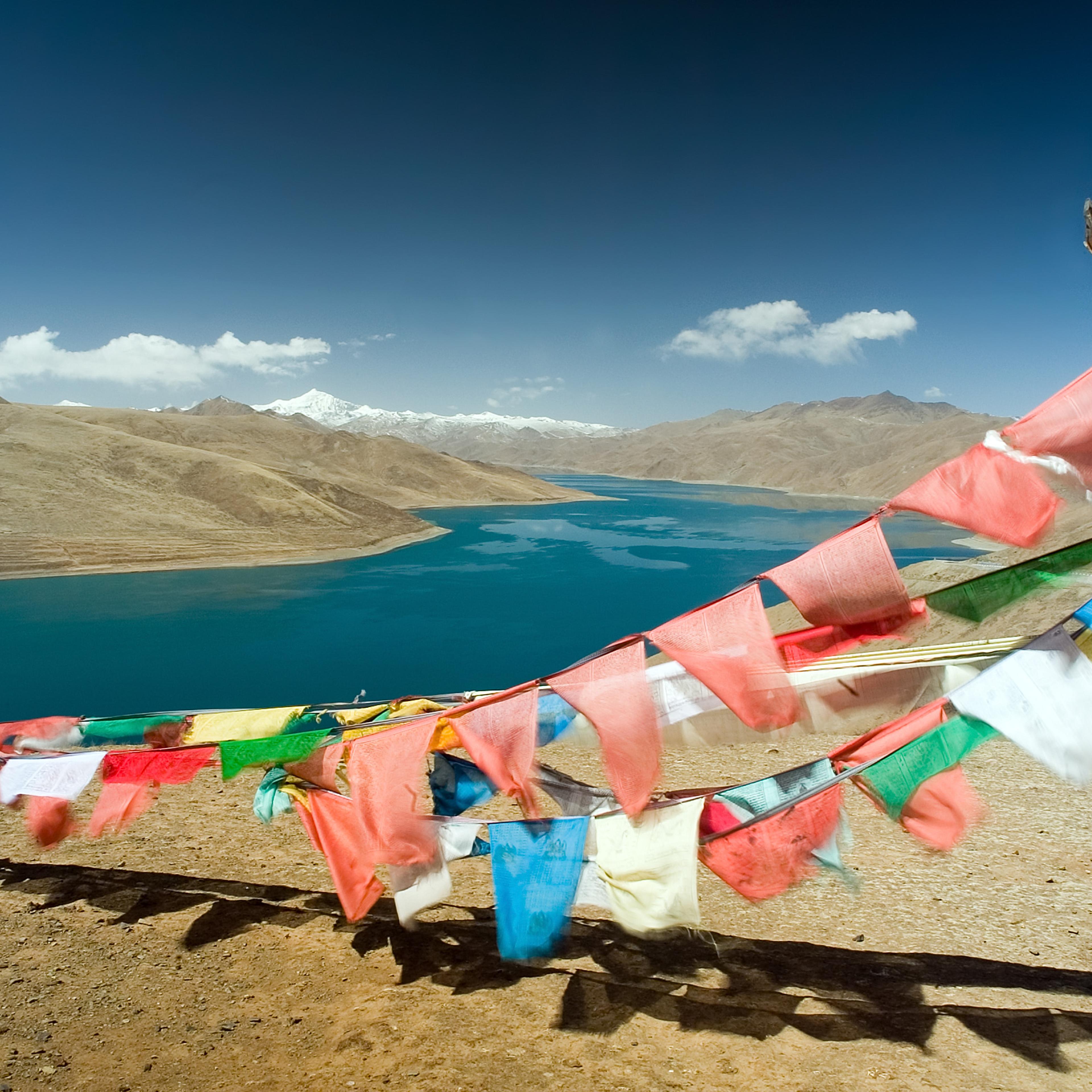 Buddhist prayer flags flutter at a pass overlooking Yamdrok