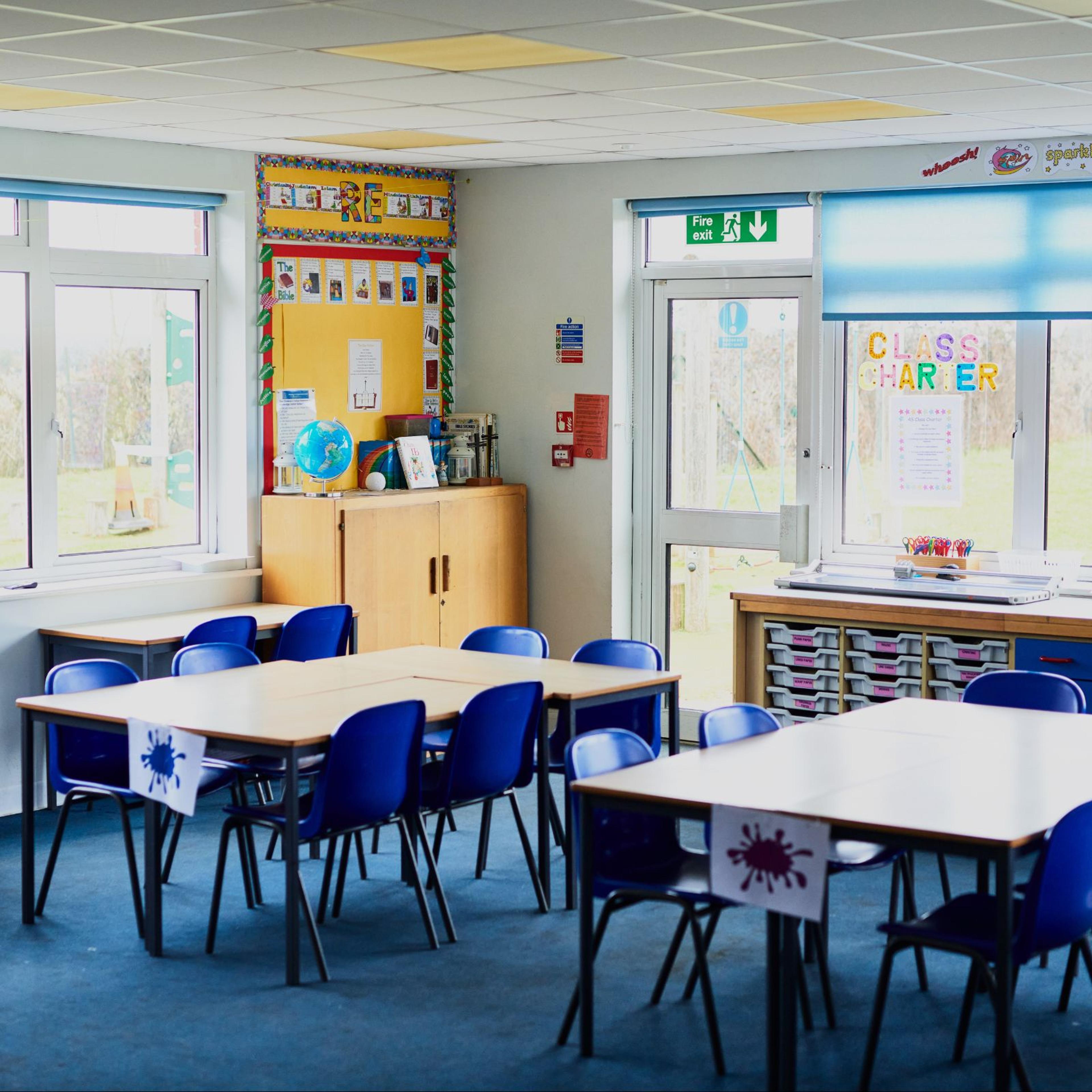 Tables and chairs arranged in a school class room.