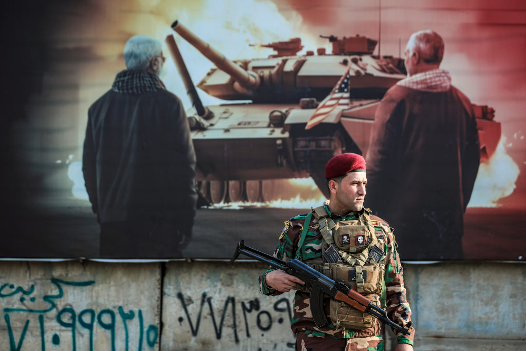 A member of the Iraqi's Popular Mobilization Forces (Hashed al-Shaabi) stands guard on Feb. 4, 2024 during the funeral of the 16 members killed in U.S. airstrikes.