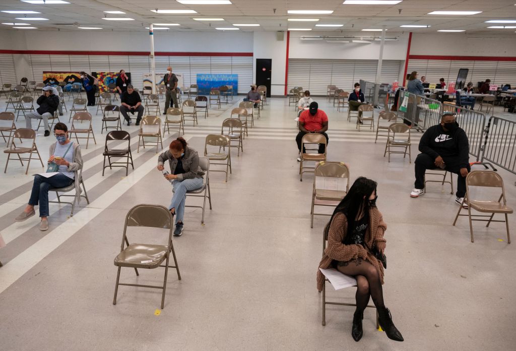 People wait in a observation area after getting a Covid-19 vaccination at an old TJ Maxx store used by Lynchburg Fire Department as a mass Covid-19 vaccination site in Lynchburg, Virginia on March 13