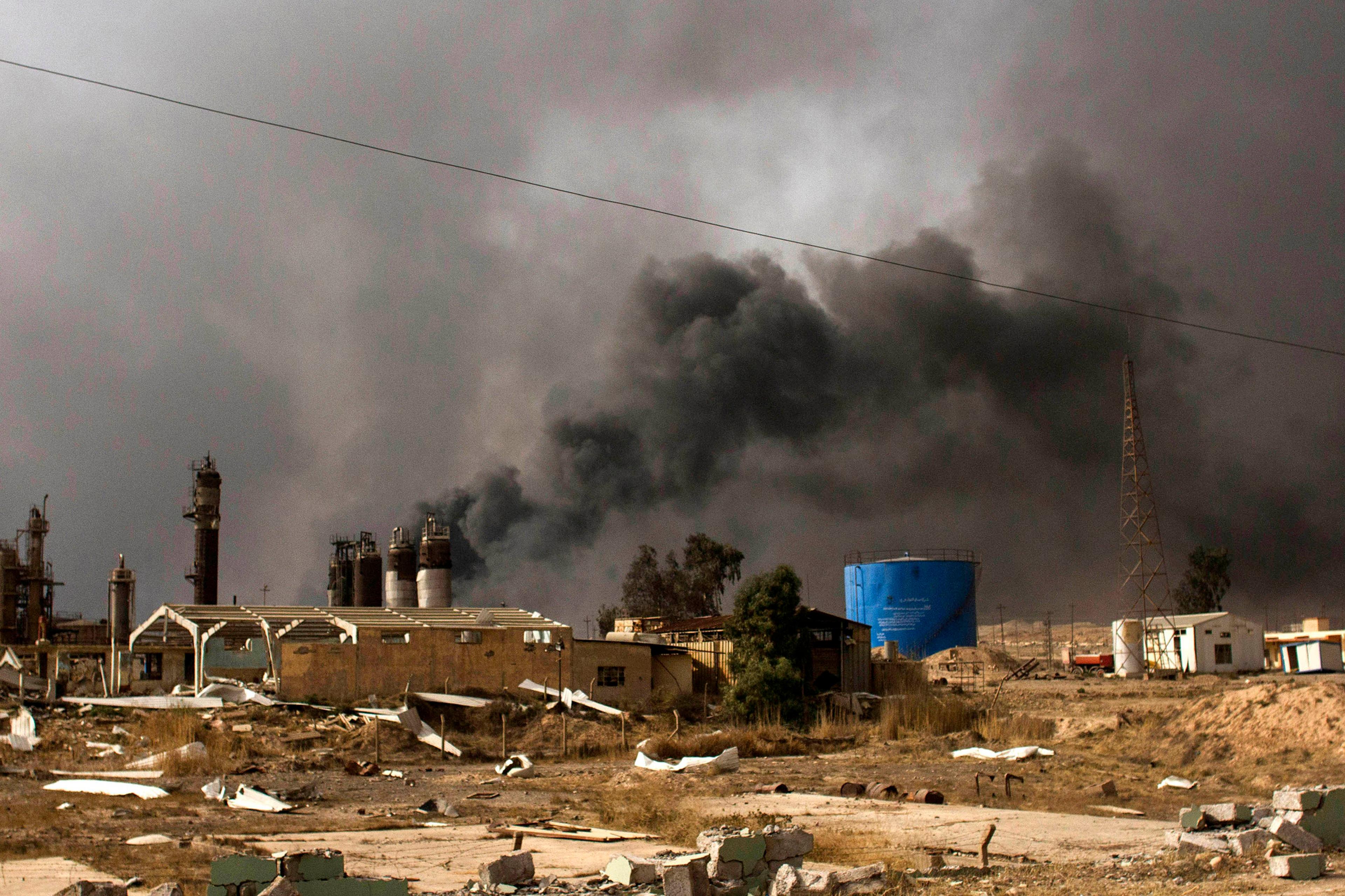 Oil wells on the edge of Qaraya, Iraq burn days after the town was retaken from the Islamic State group by Iraqi ground forces backed by U.S.-led coalition airpower. The operation is part of a strategy to isolate Mosul, Aug. 28, 2016.