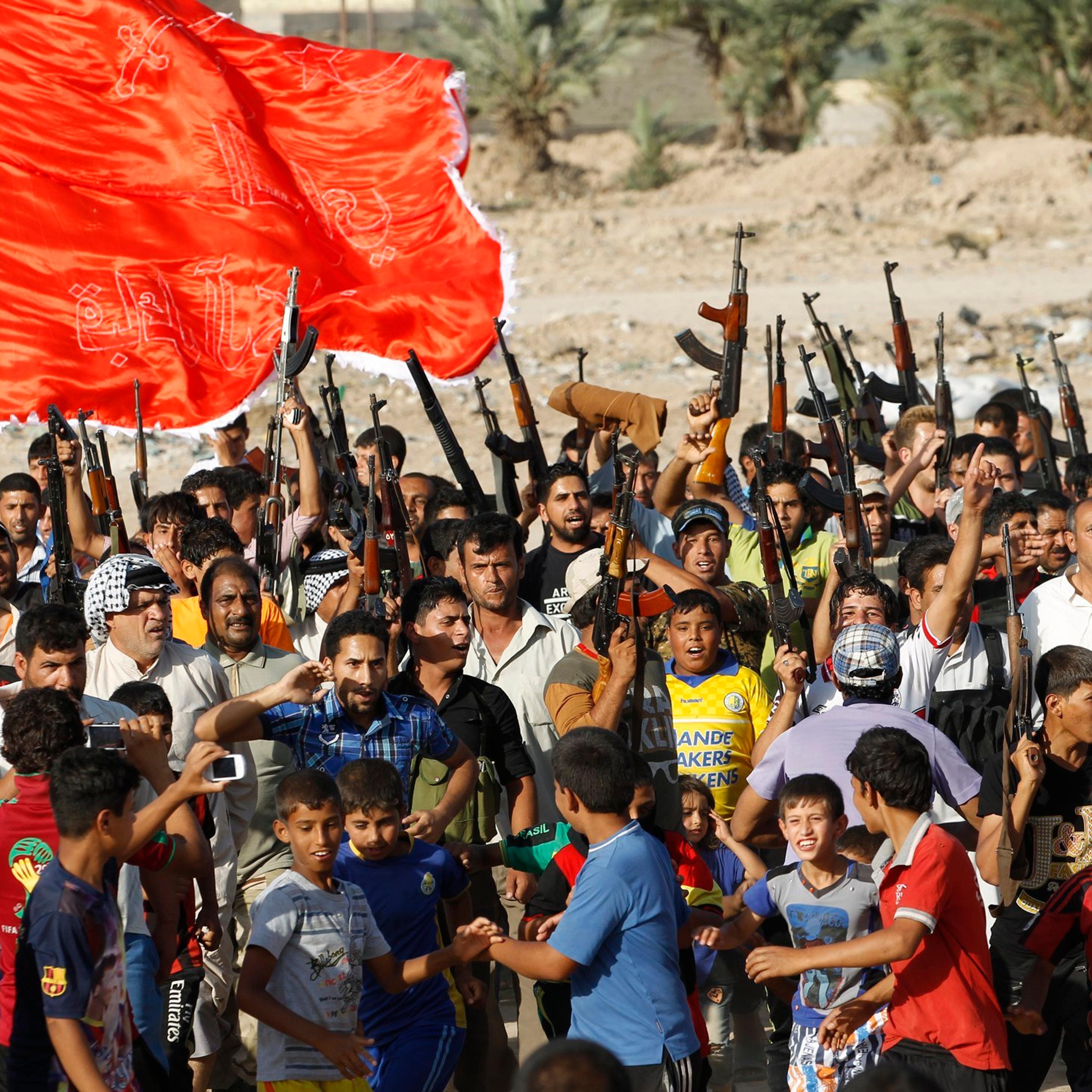 Volunteers, who have joined the Iraqi Army to fight against predominantly Sunni militants from the radical Islamic State of Iraq and the Levant, carry weapons during a parade in Al-Fdhiliya district