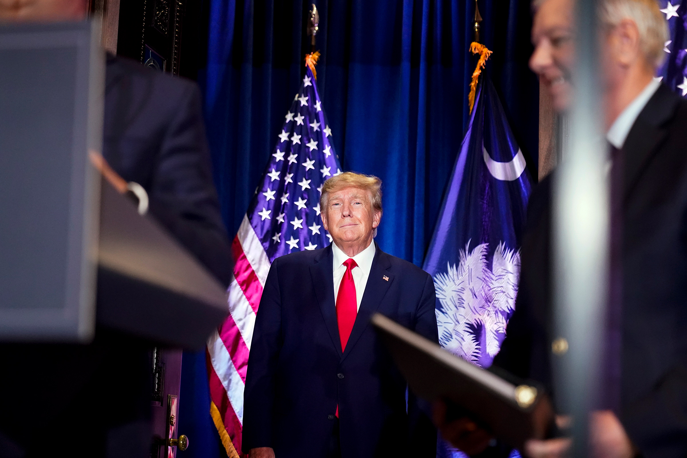 Former President Donald Trump arrives to speak at a campaign event at the South Carolina Statehouse on Jan. 28, in Columbia, S.C. Sen. Lindsey Graham, R-S.C., is at right. 